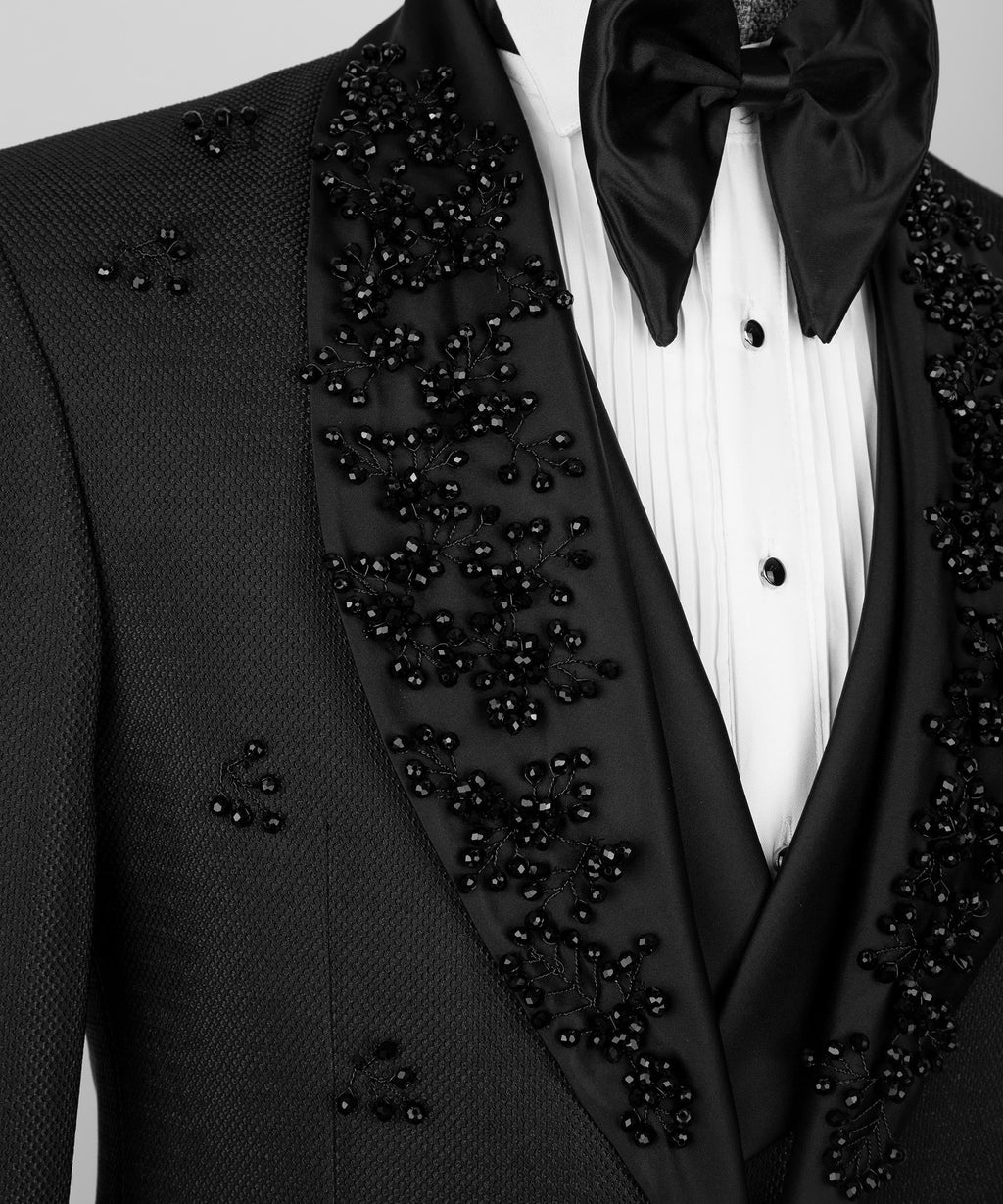Black tuxedo jacket detail with crystal-jeweled lapel and white vest front