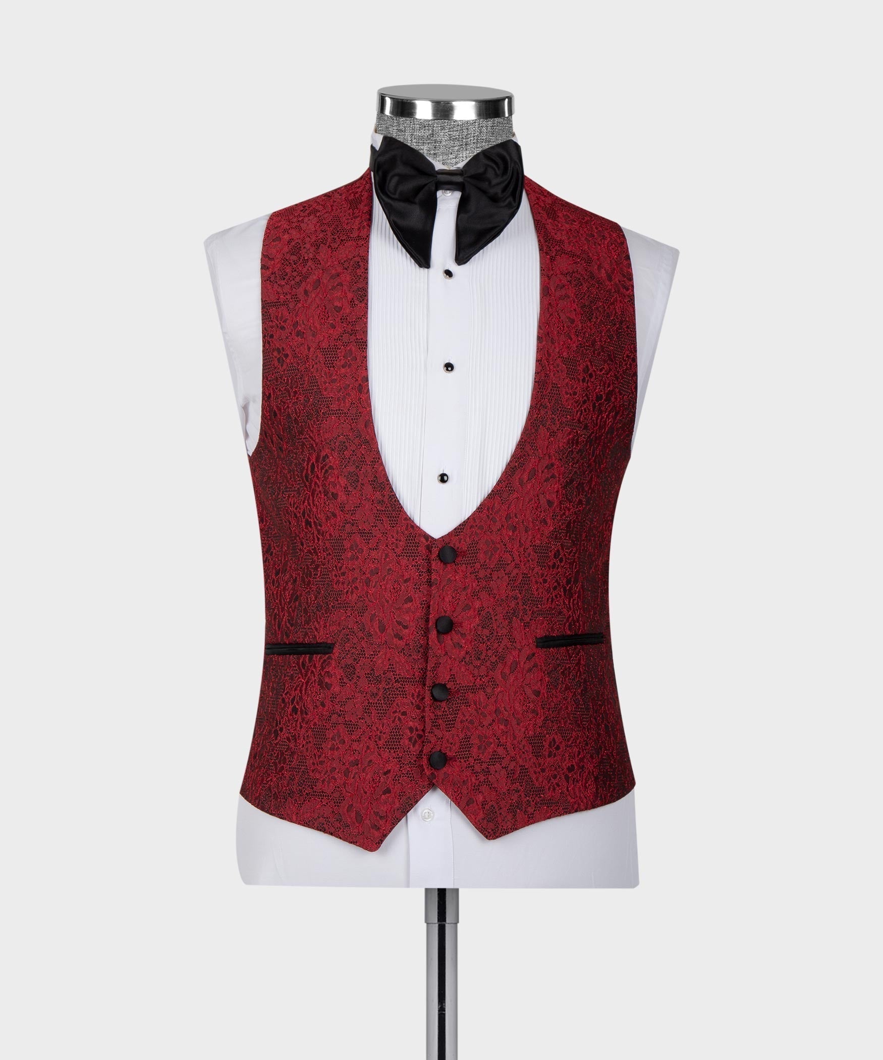 Red patterned tuxedo vest with black satin lapels and black bow tie over white shirt