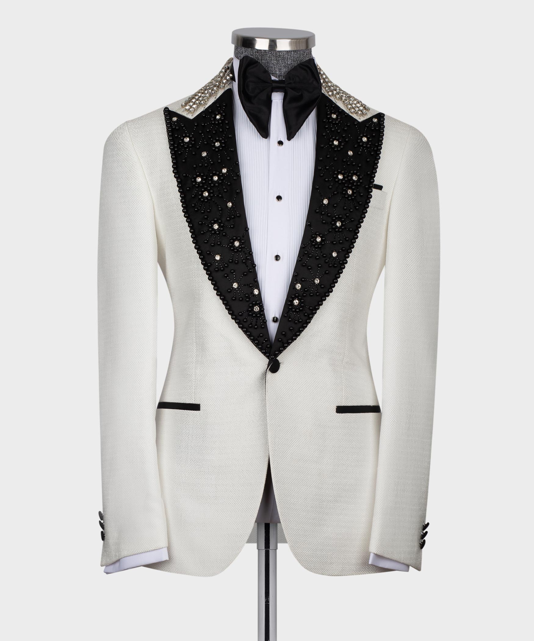 White tuxedo jacket with black jeweled lapels, black bow tie, white shirt
