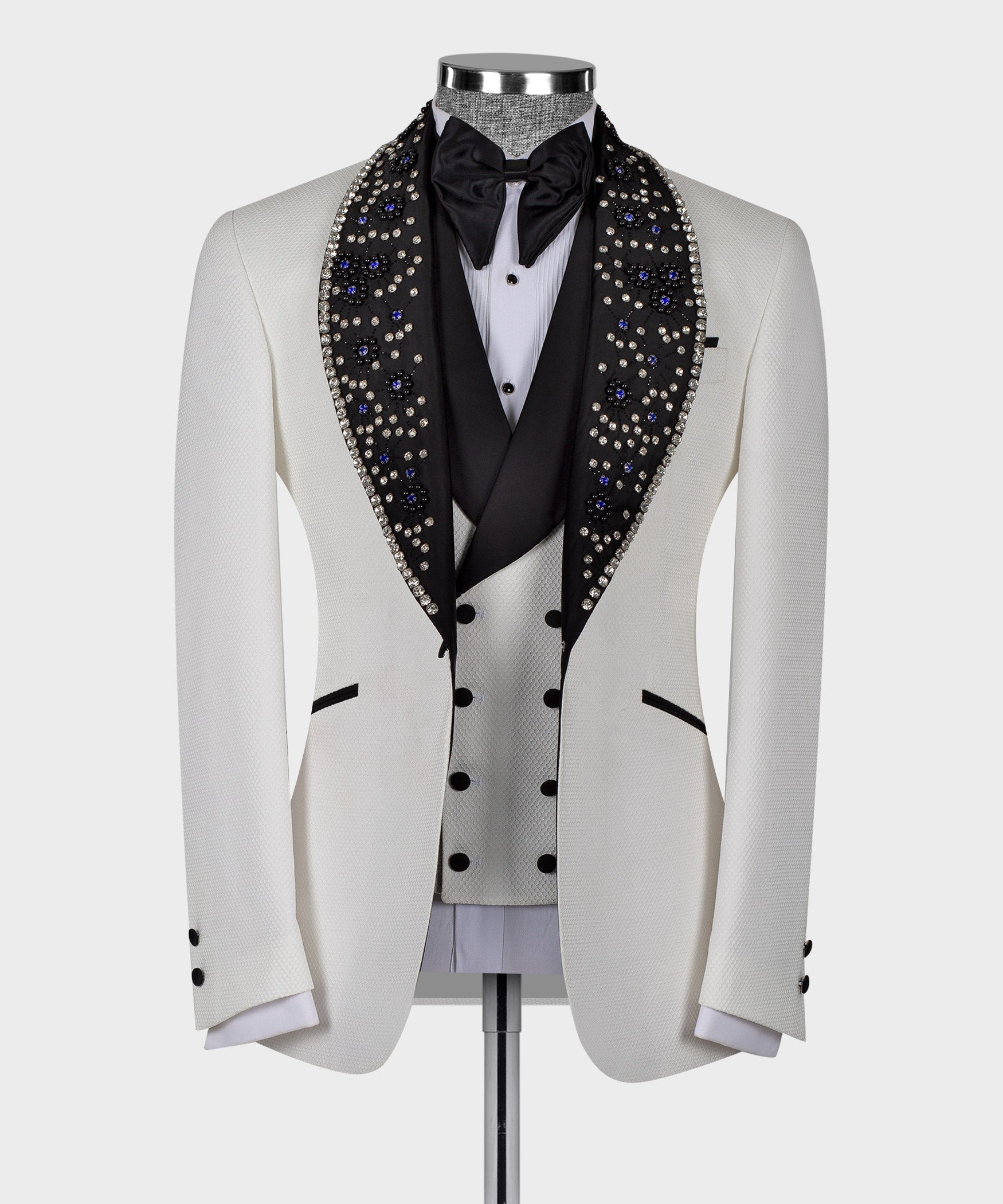 White tuxedo jacket with black satin bow tie and blue crystal gem trim lapels