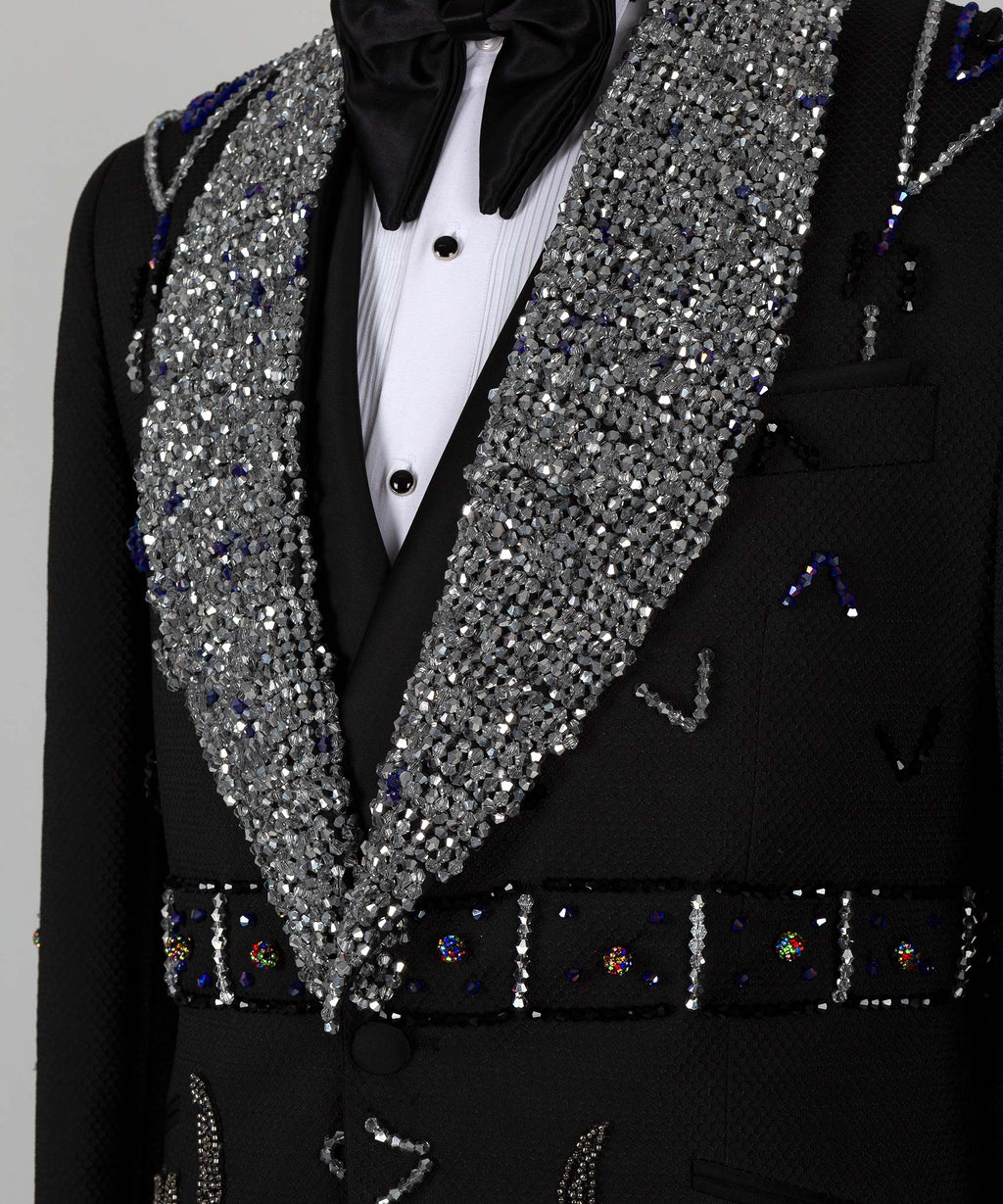 Close-up: silver sequin shawl lapels, black satin bow tie, and tuxedo pocket