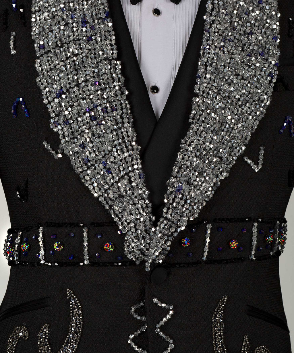 Close-up: sequin lapels with jeweled trim and ornate black vest details