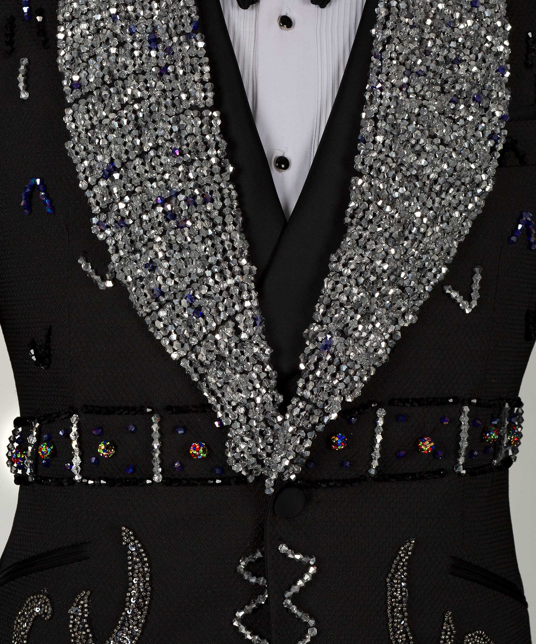 Close-up: sequin lapels with jeweled trim and ornate black vest details