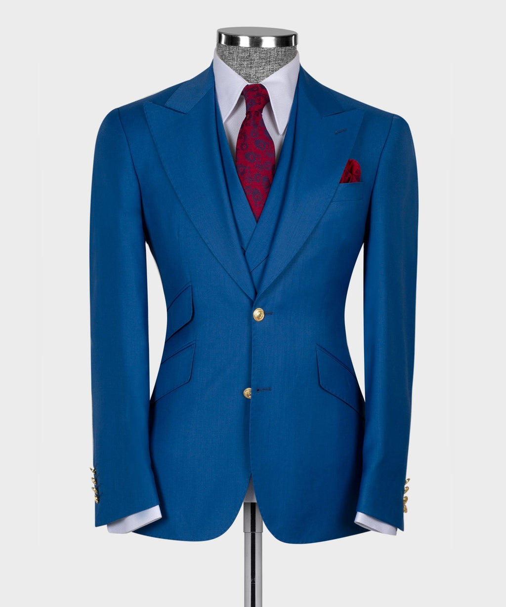 Blue tailored suit jacket with gold buttons and red pocket square over white shirt