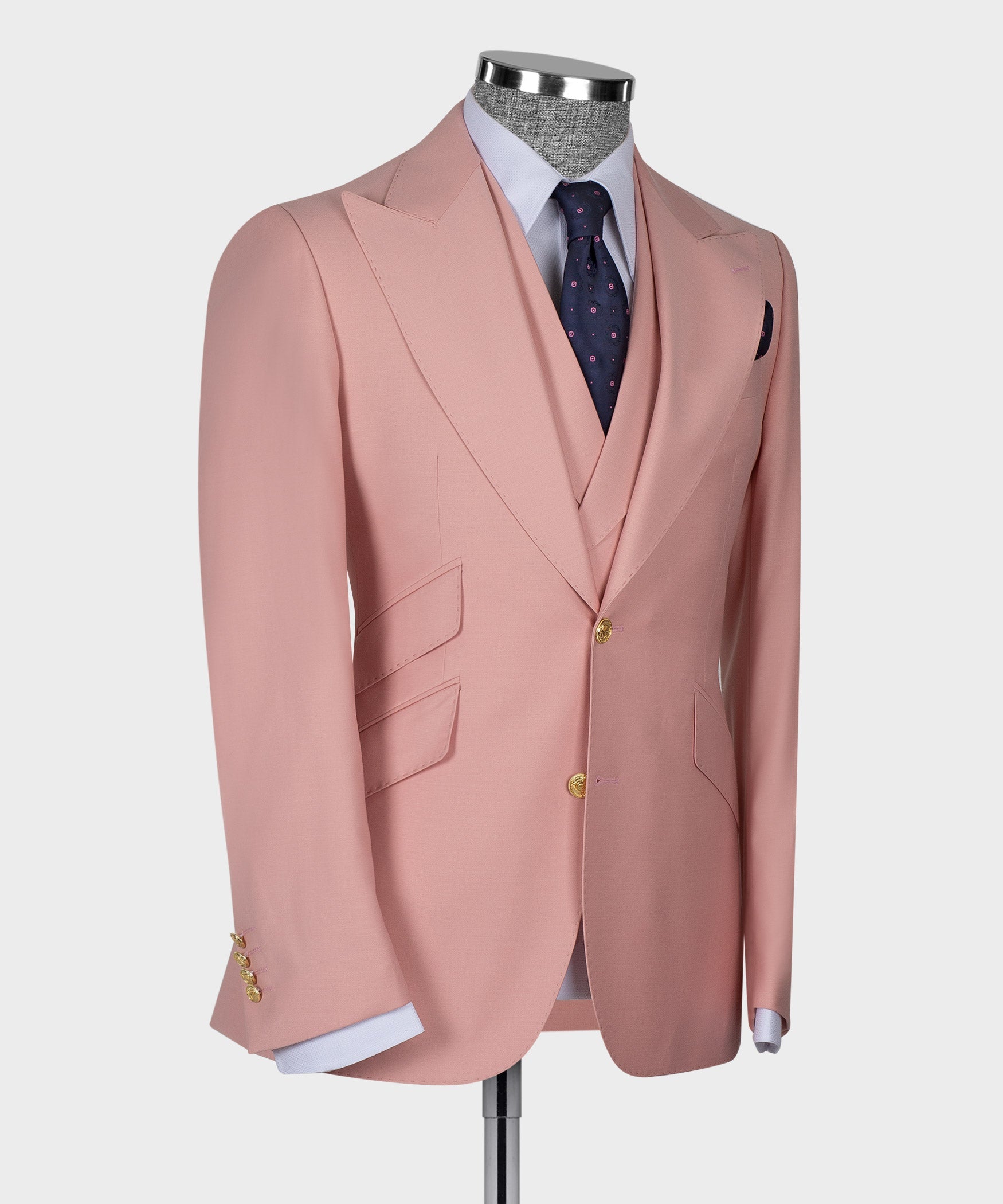 Powder pink suit jacket front view with gold button closure and dark patterned tie