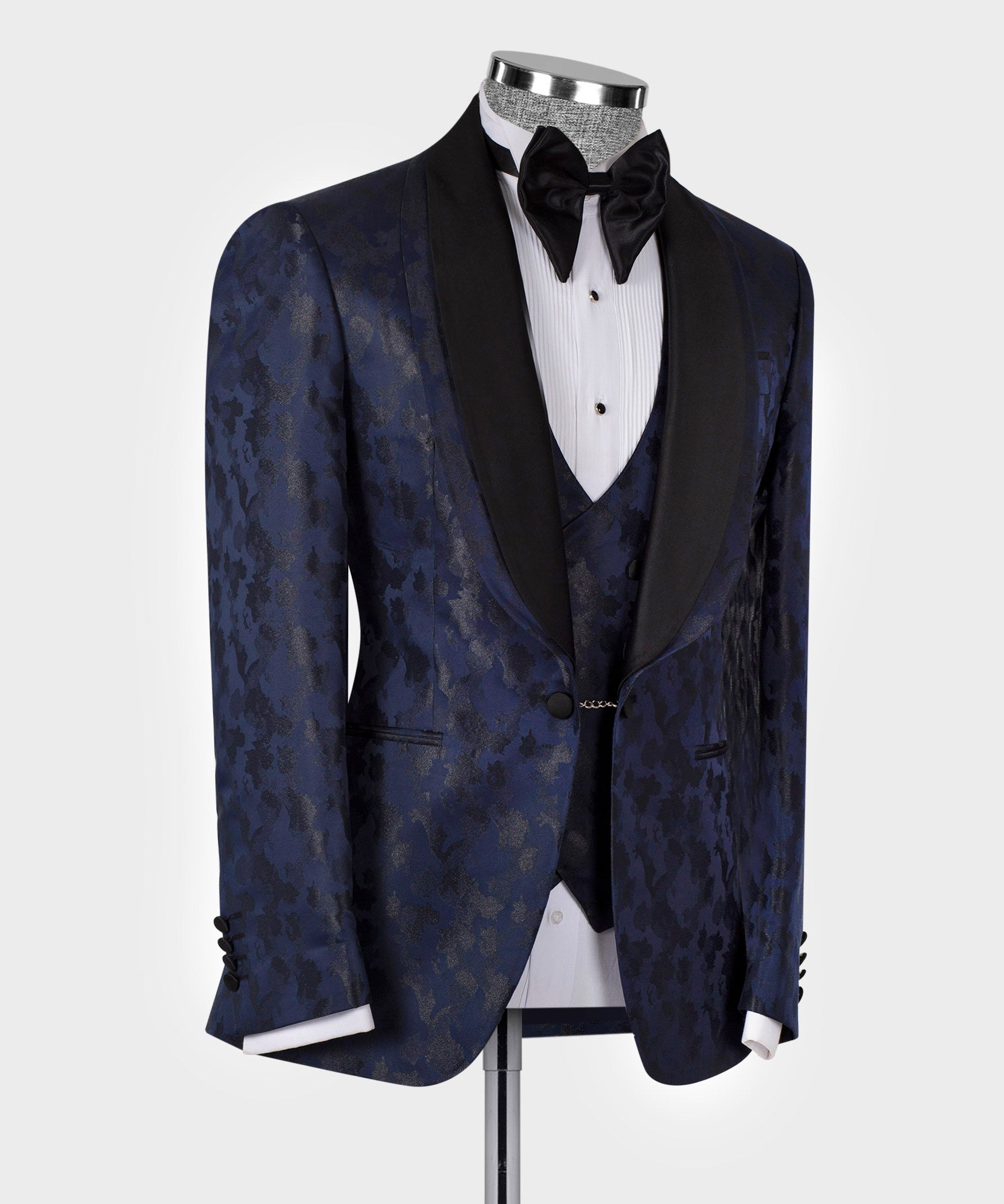 Navy tuxedo jacket with black lapels, button front, and patterned fabric; bow tie