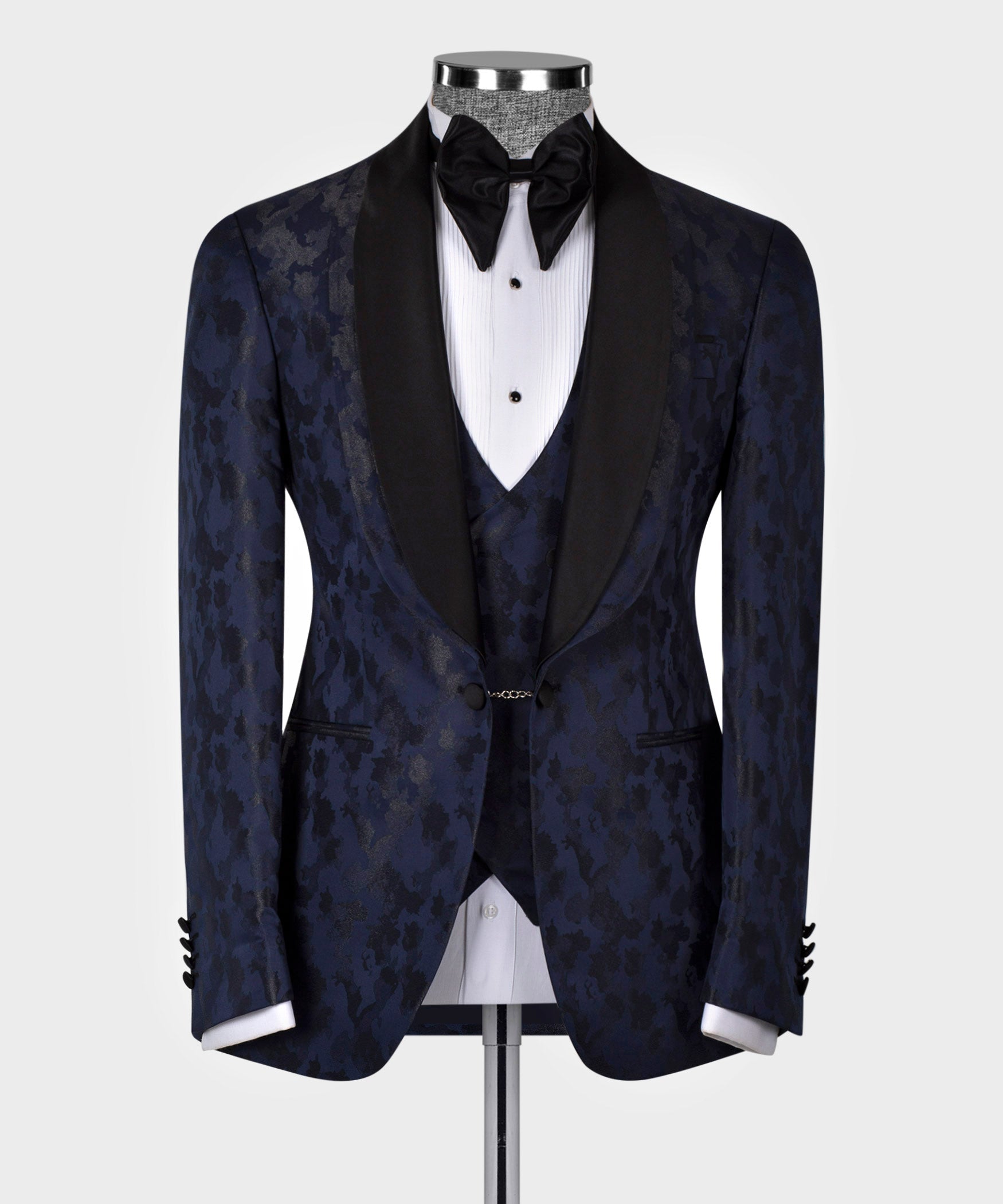 Navy tuxedo suit jacket with double lapels over black vest, white dress shirt, bow tie