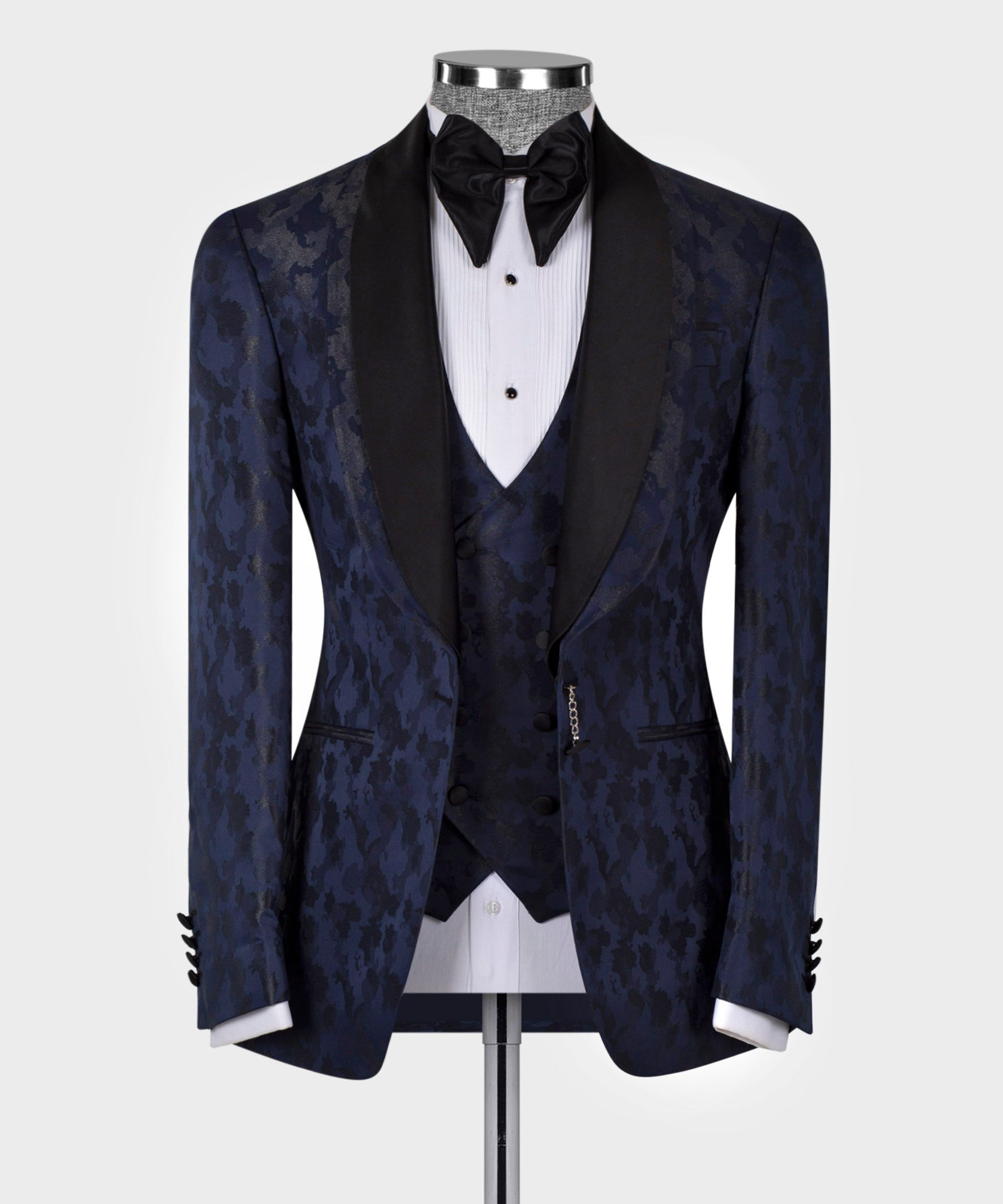 Navy tuxedo jacket with black satin lapels, bow tie, and patterned front vest