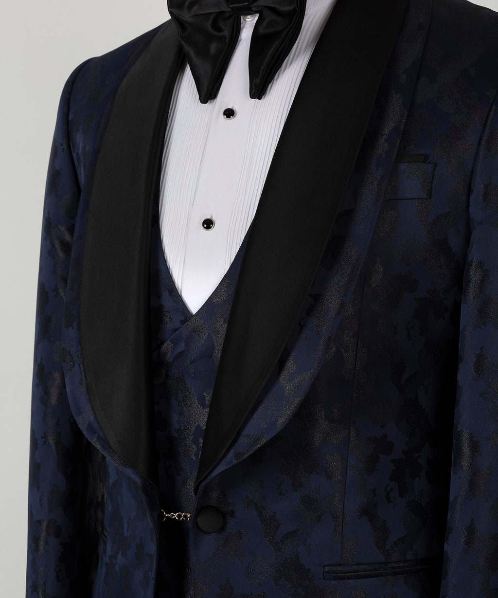 Navy tuxedo jacket lapels with black satin, bow tie, and vest button close-up