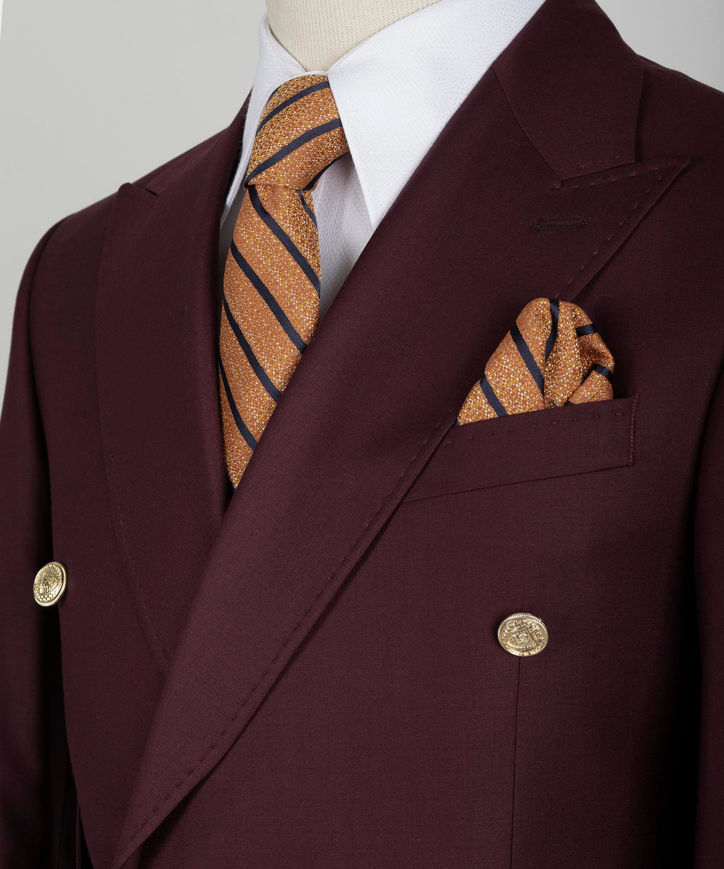 Burgundy blazer lapels with striped gold-accent tie and matching pocket square