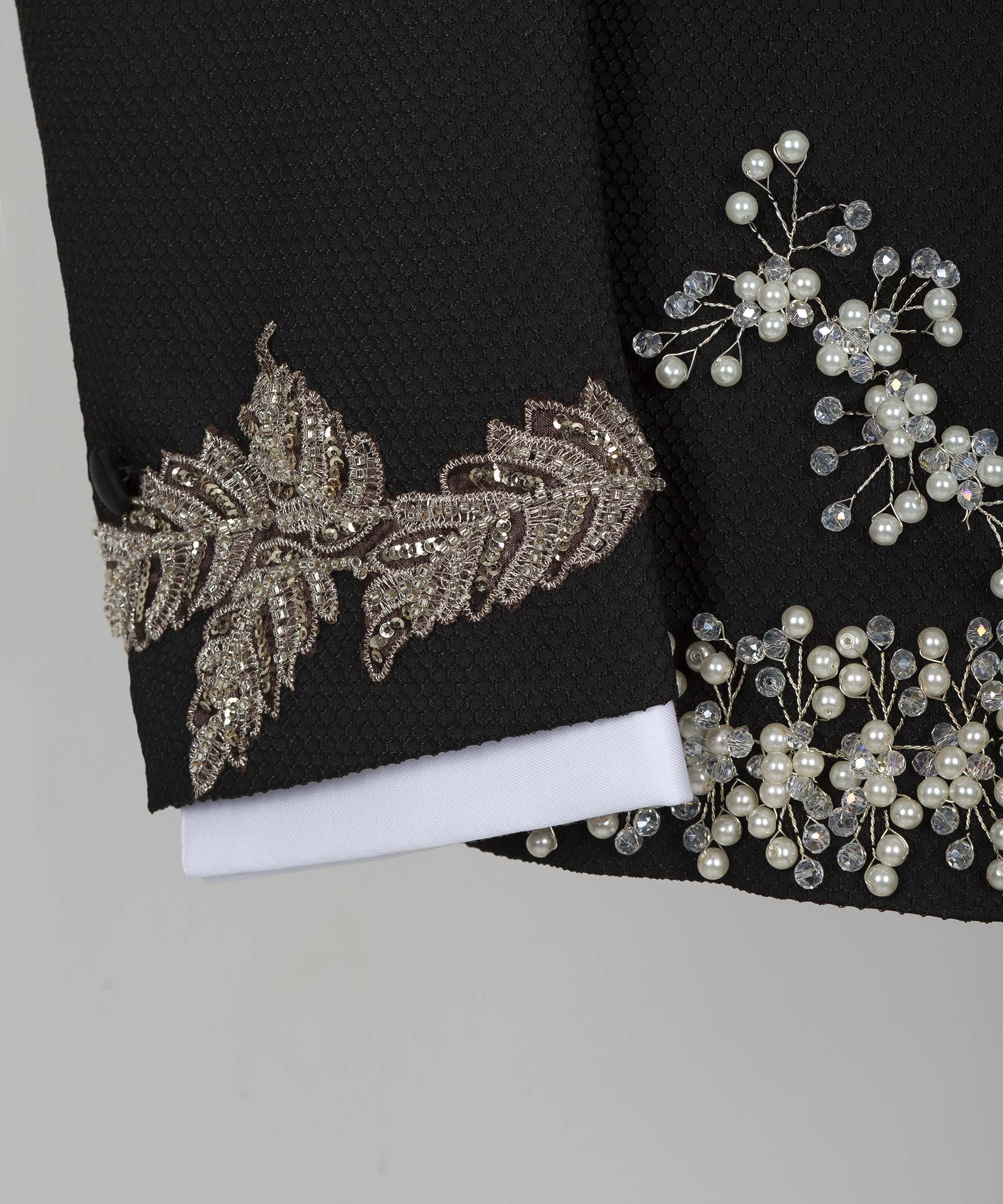 Black tuxedo jacket cuff with gold floral embroidery and pearl trim