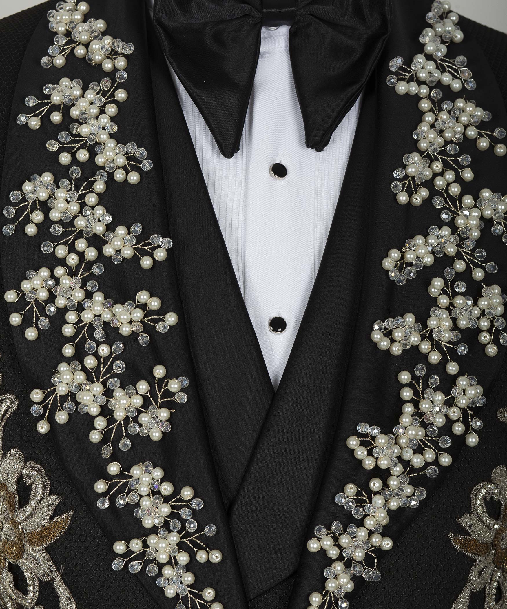 Close-up of black tuxedo jacket lapels with pearl, crystal, and gold floral appliqués