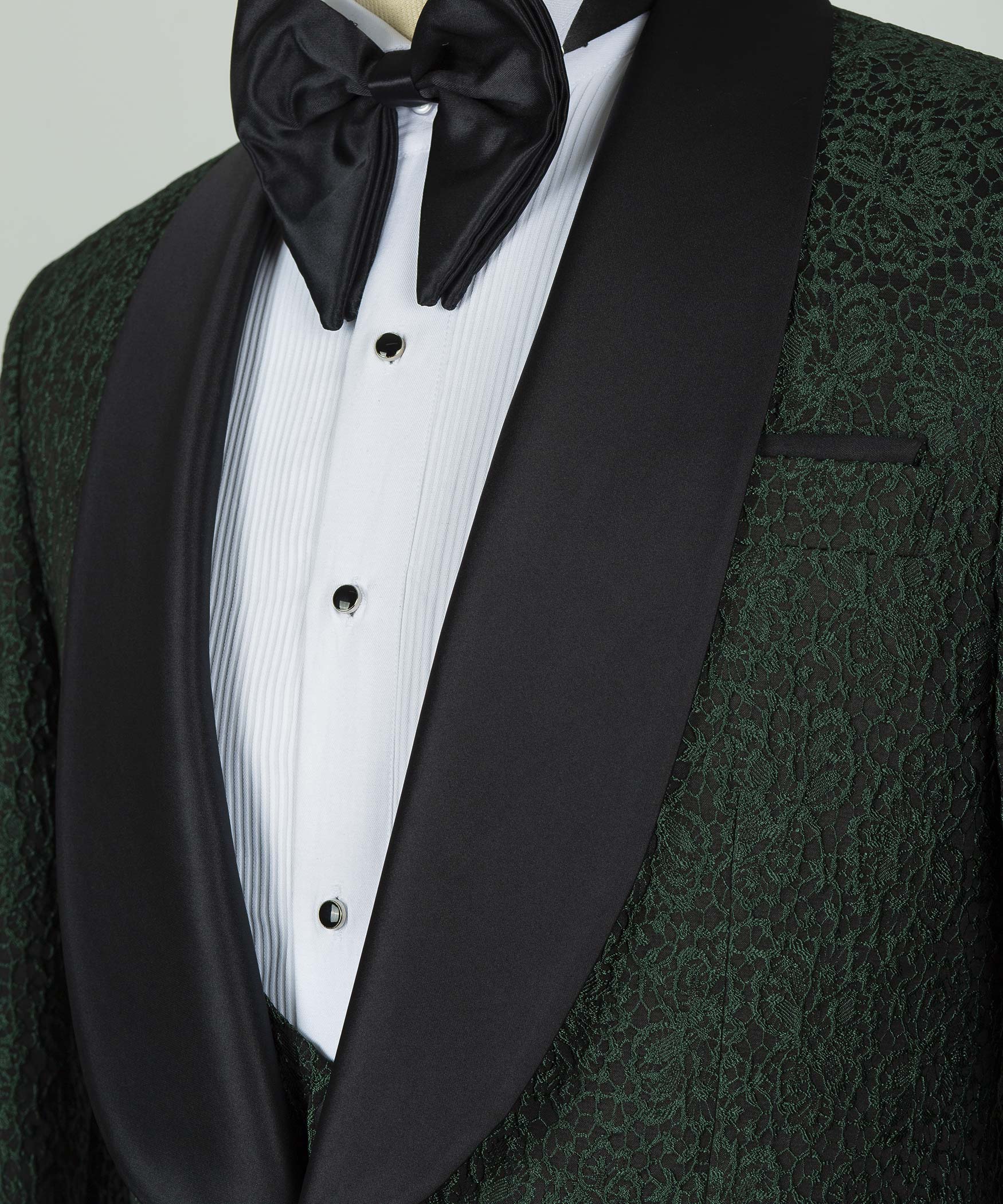 Black satin bow tie with white striped shirt and green patterned waistcoat