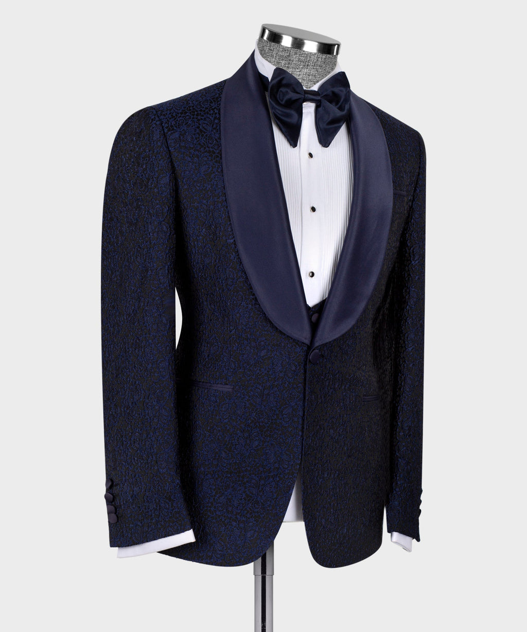 Three-piece tuxedo suit in dark blue: bow tie and satin-trimmed lapels, side view.