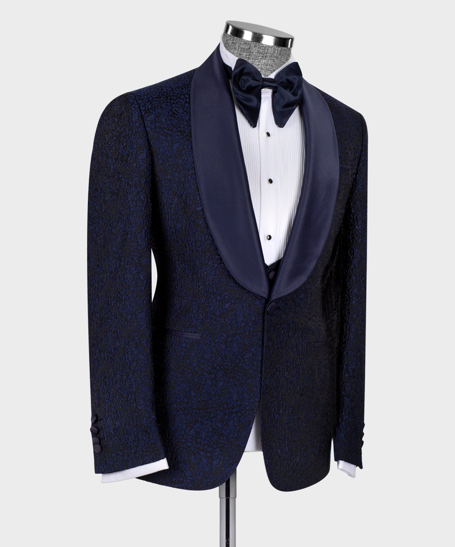 Three-piece tuxedo suit in dark blue: bow tie and satin-trimmed lapels, side view.