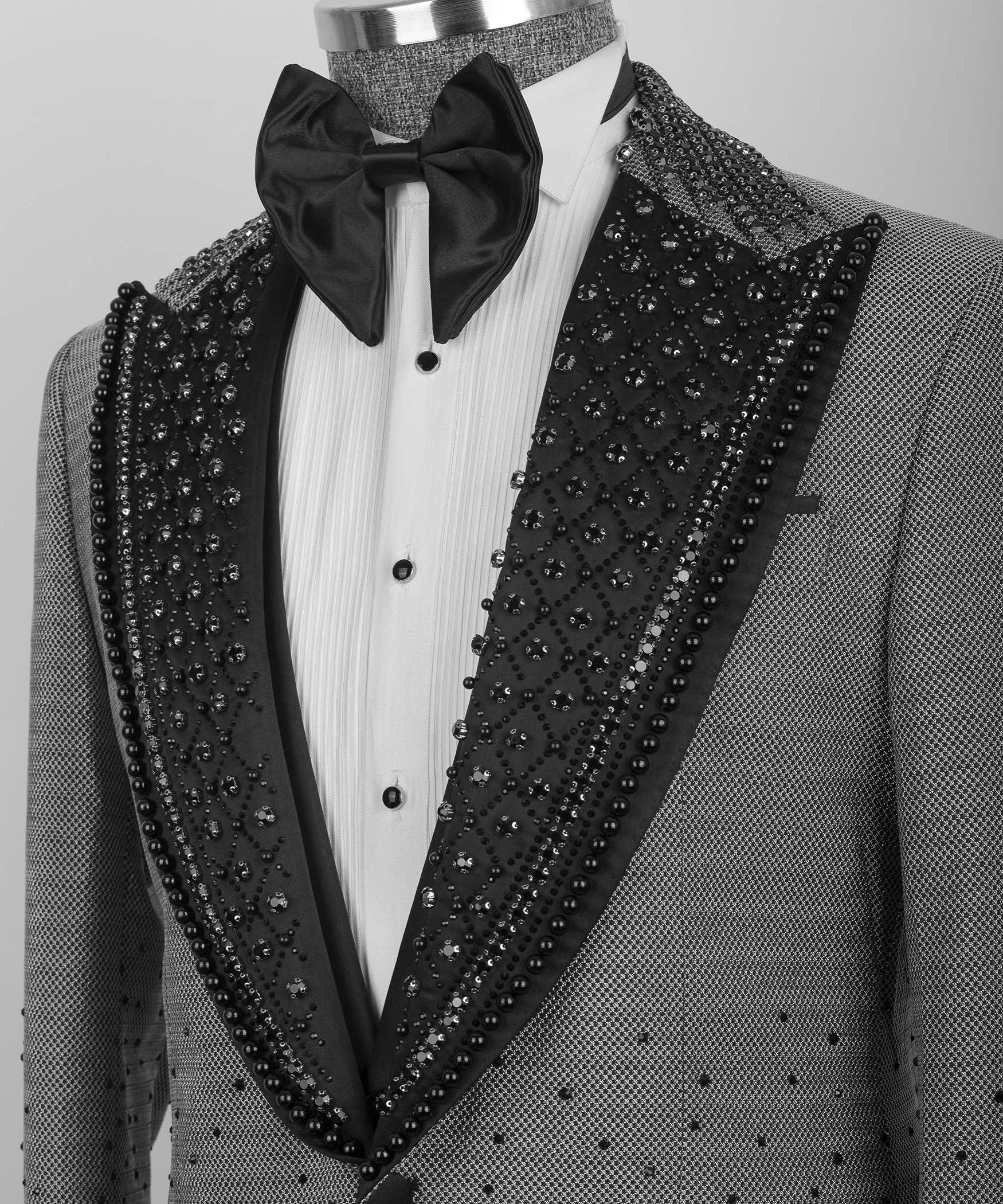 Close-up gray tuxedo lapels with black beaded trim over white shirt and black bow tie