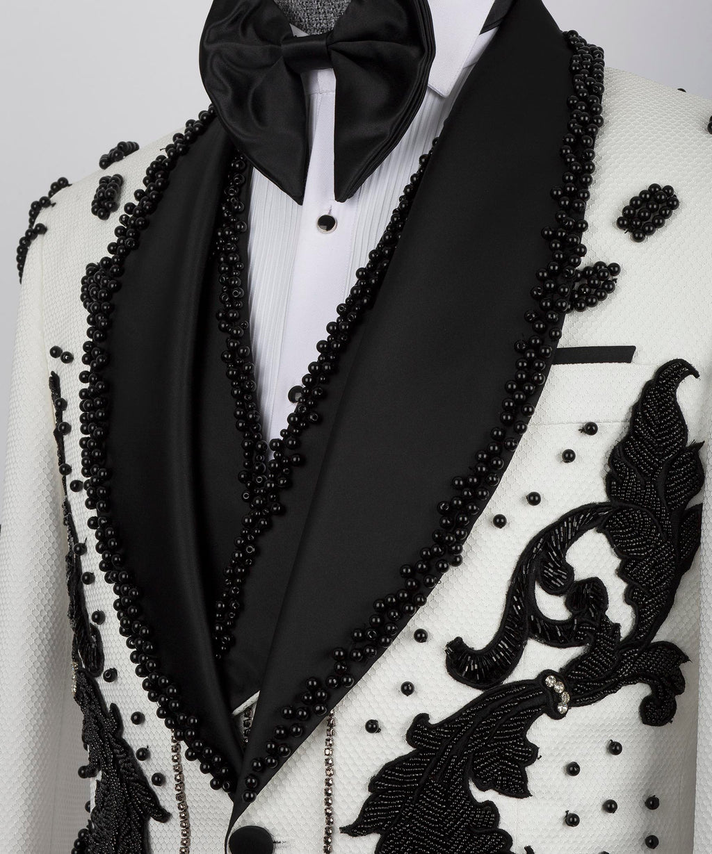 Close-up: black satin lapels with bow tie and pearl-like bead accents