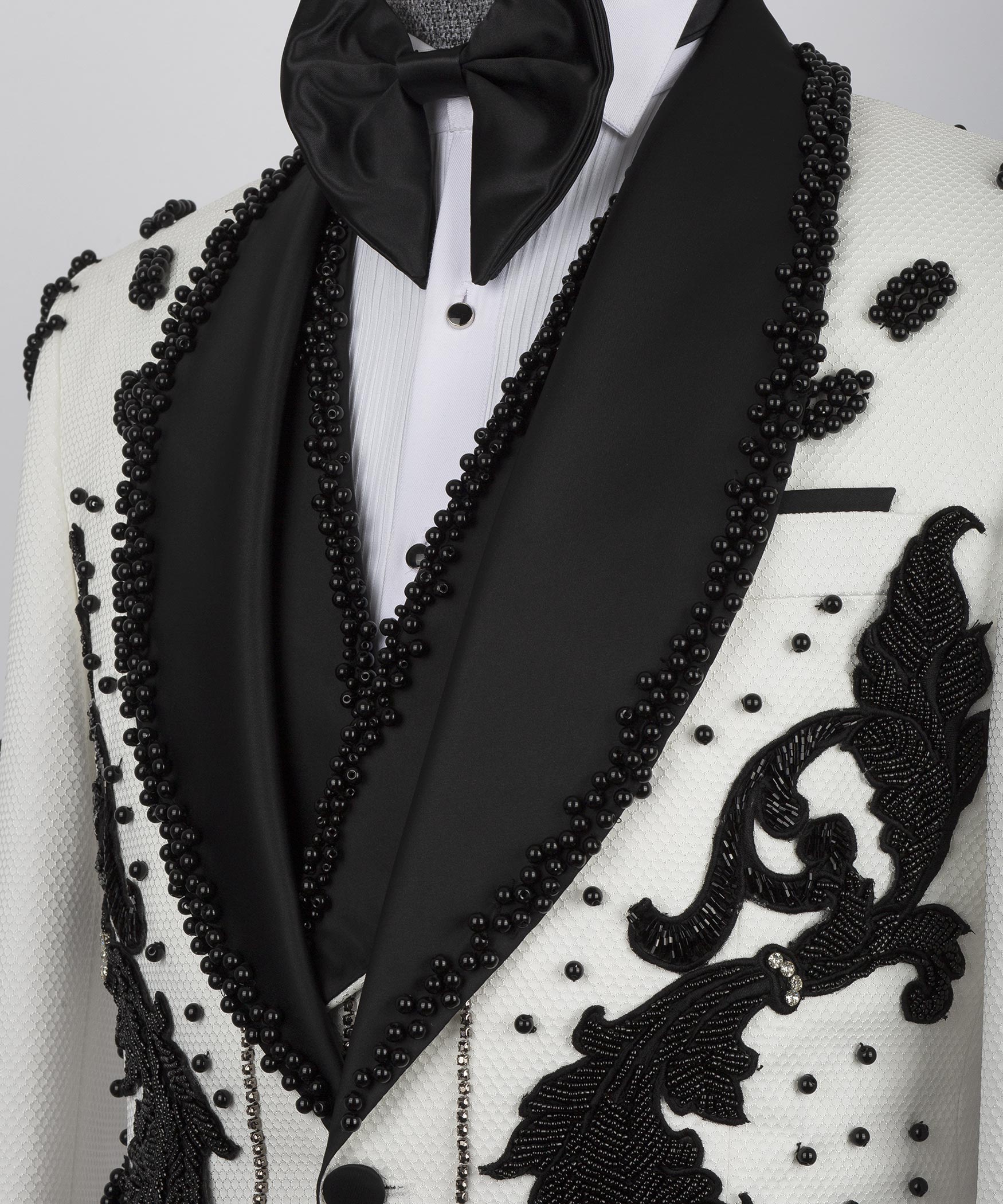 Close-up: black satin lapels with bow tie and pearl-like bead accents