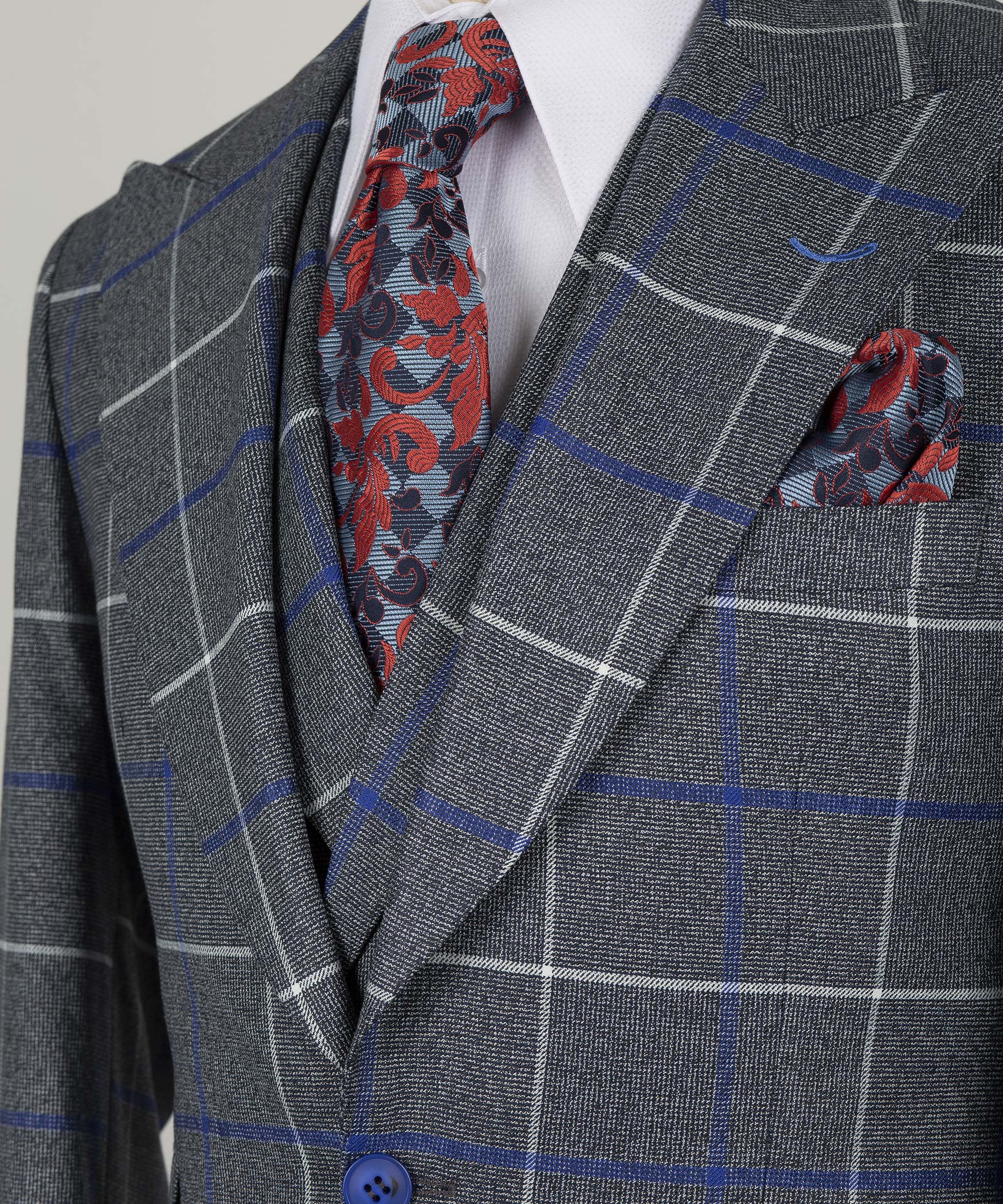 Close-up lapel and pocket square: blue grid dark gray blazer with red patterned accents