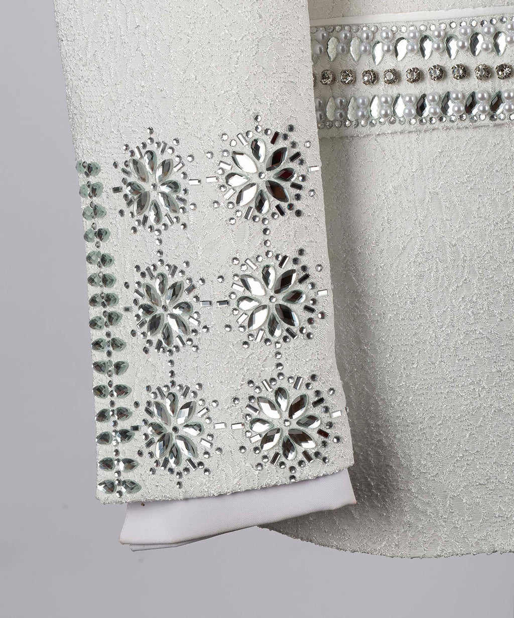 White tuxedo sleeve cuff with snowflake crystal motifs and sparkling beadwork border
