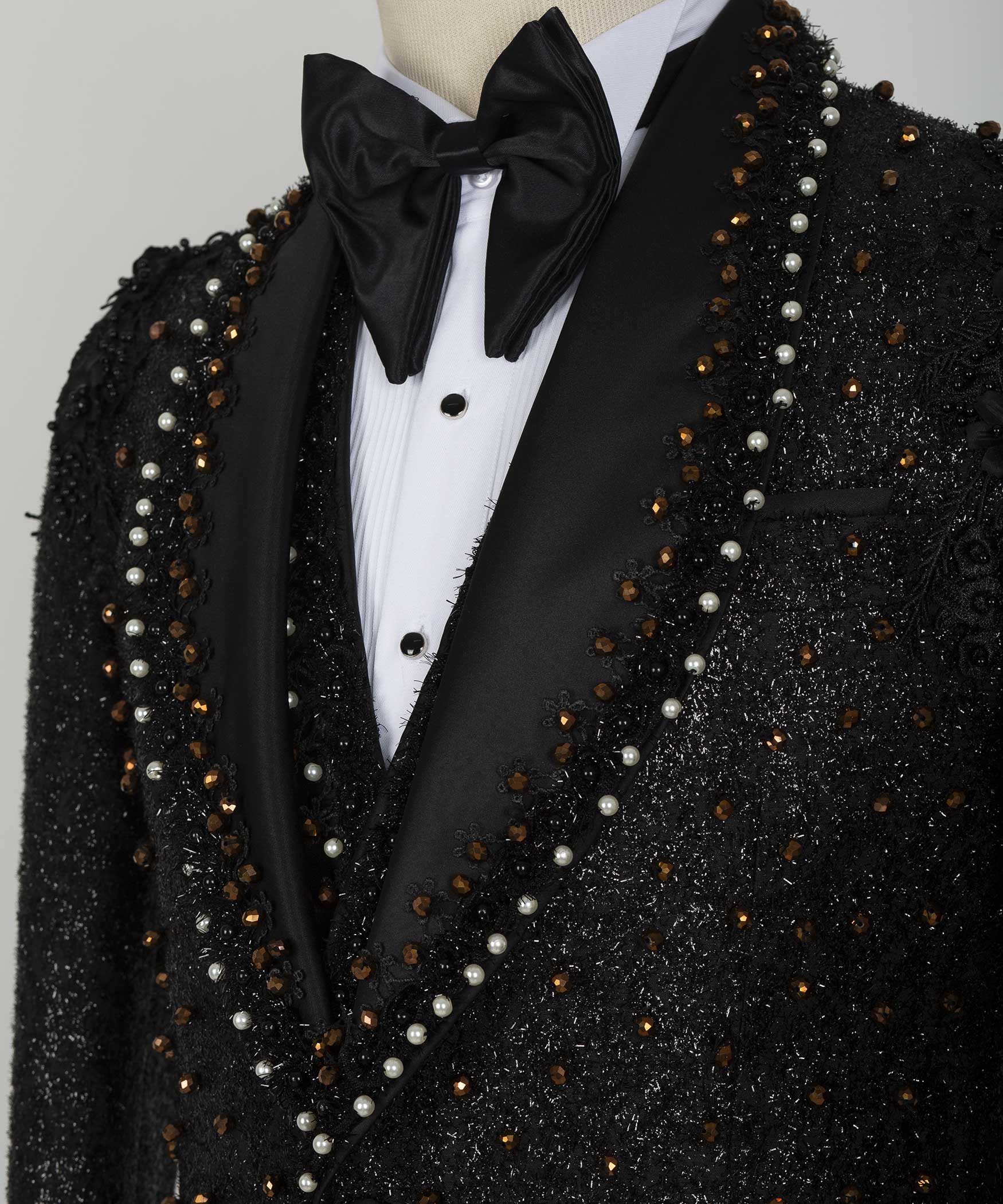 Close-up black tuxedo lapels with pearl and crystal bead strands and satin bow