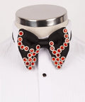 Koss Atelier black silk bow tie adorned with red crystal flower-shaped embellishments on a white pleated shirt.
