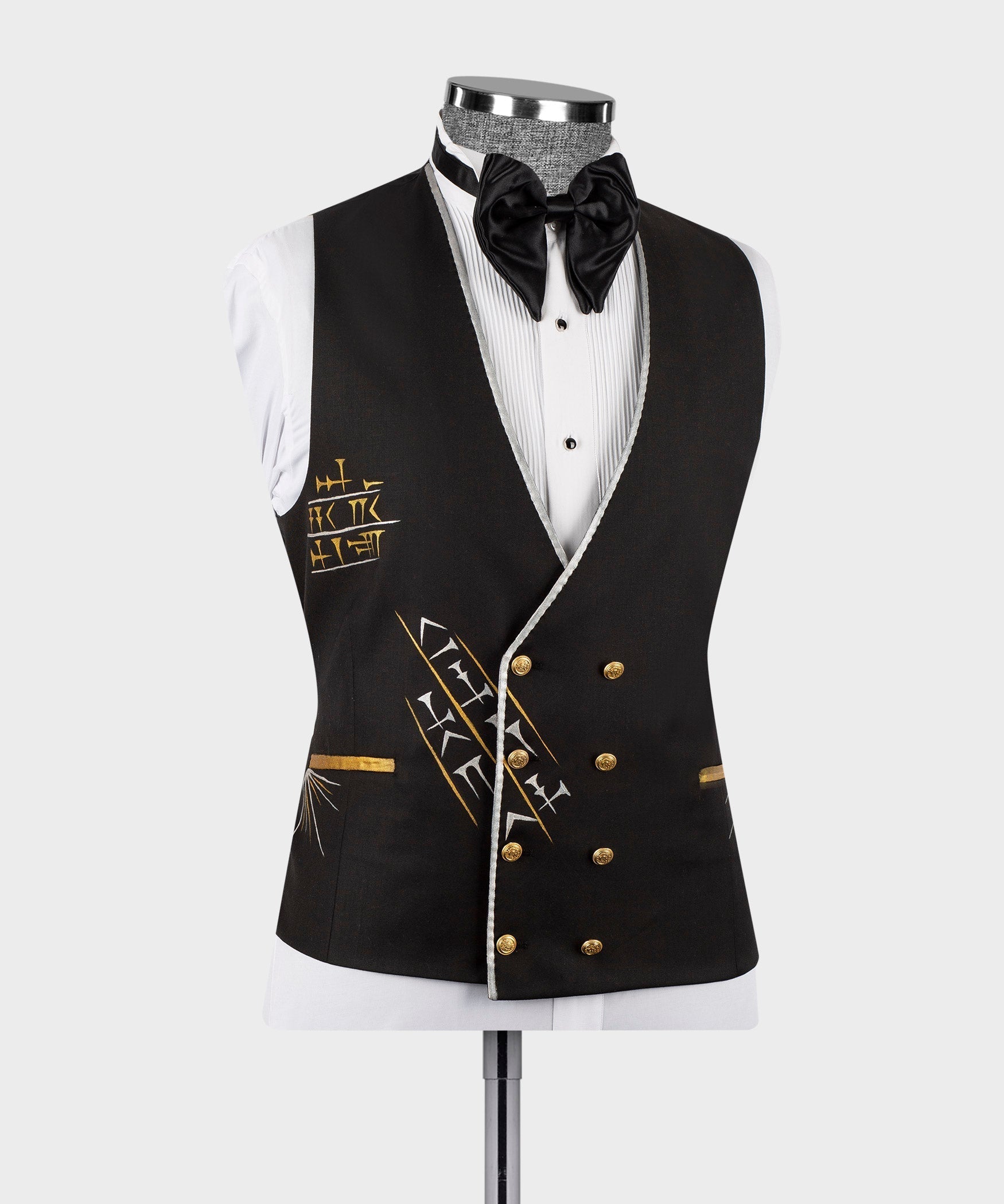 Black tuxedo jacket on mannequin with satin lapels, gold buttons, and black bow tie