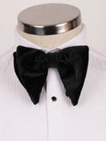 A black velvet bow tie displayed on a white pleated dress shirt mannequin with a silver neck cap.