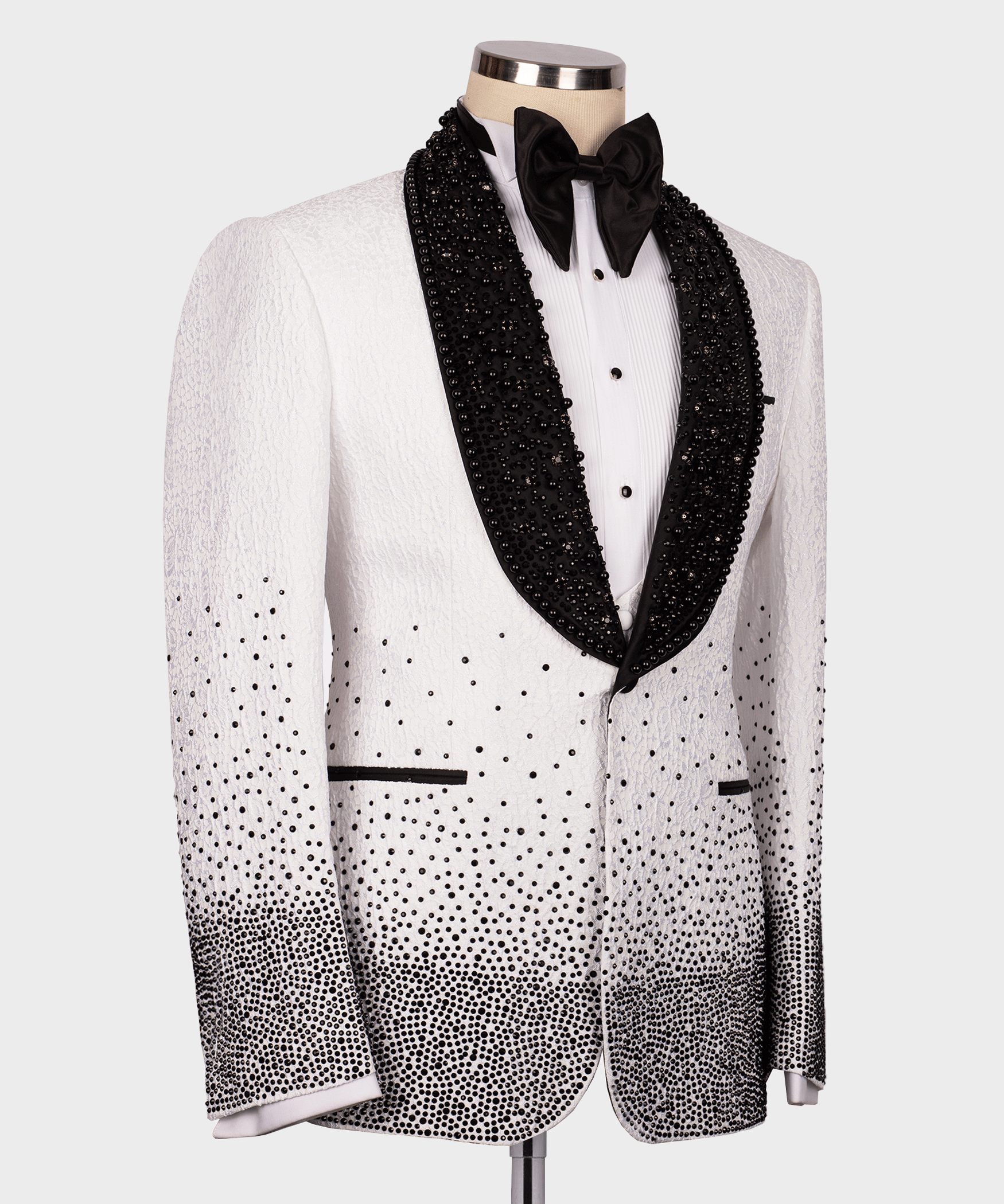White tuxedo jacket front with black bow tie, gem-studded lapels, and dotted pattern