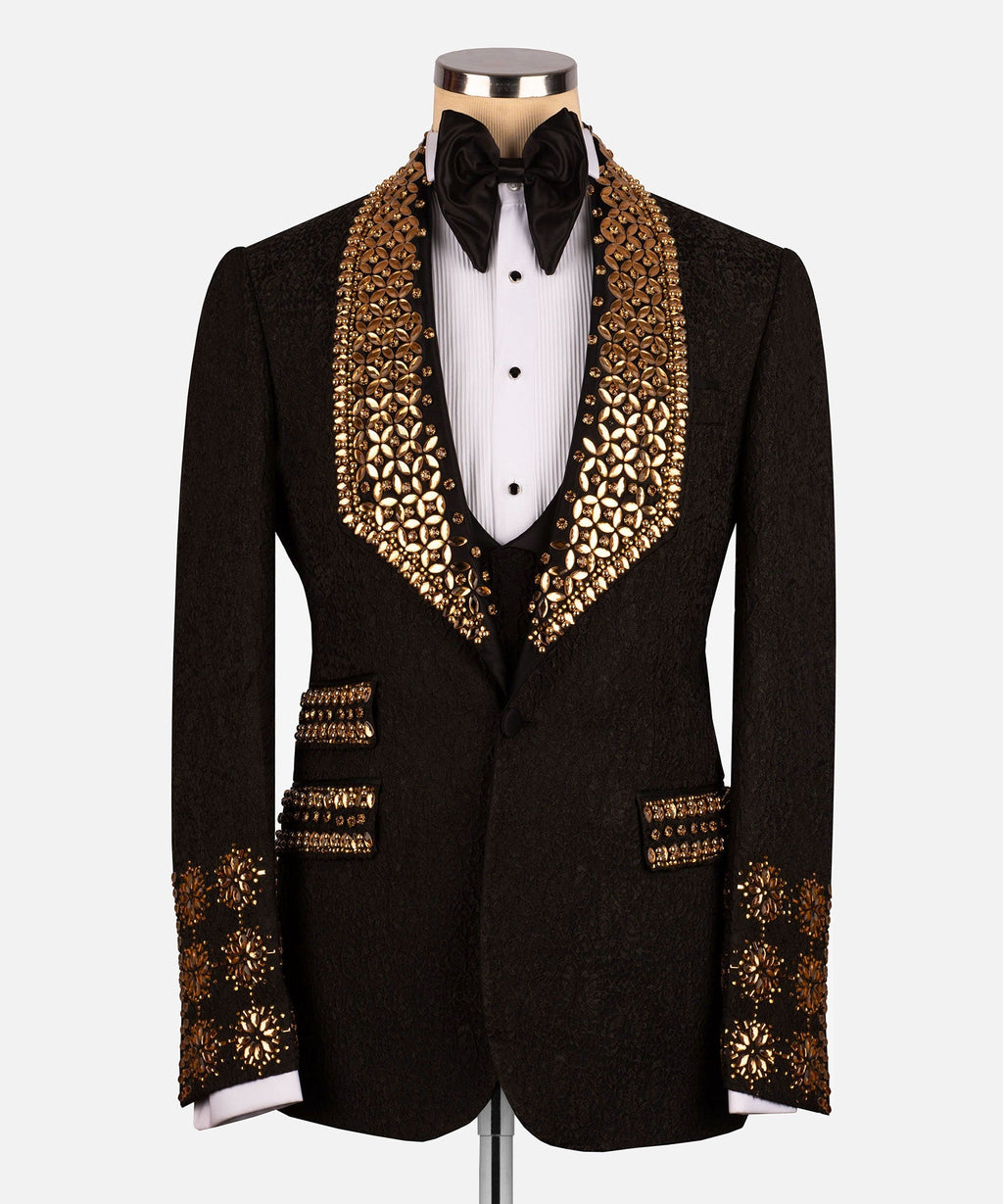 Black tuxedo jacket with gold gem-like trim on lapels, cuffs, and pockets; black bow tie