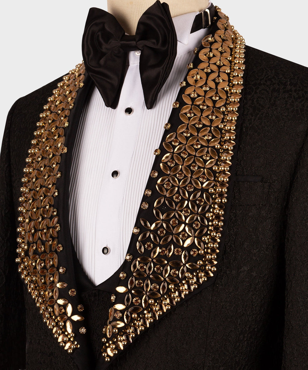 Close-up of tuxedo: white shirtfront with black bow tie and gold embellished shawl lapels