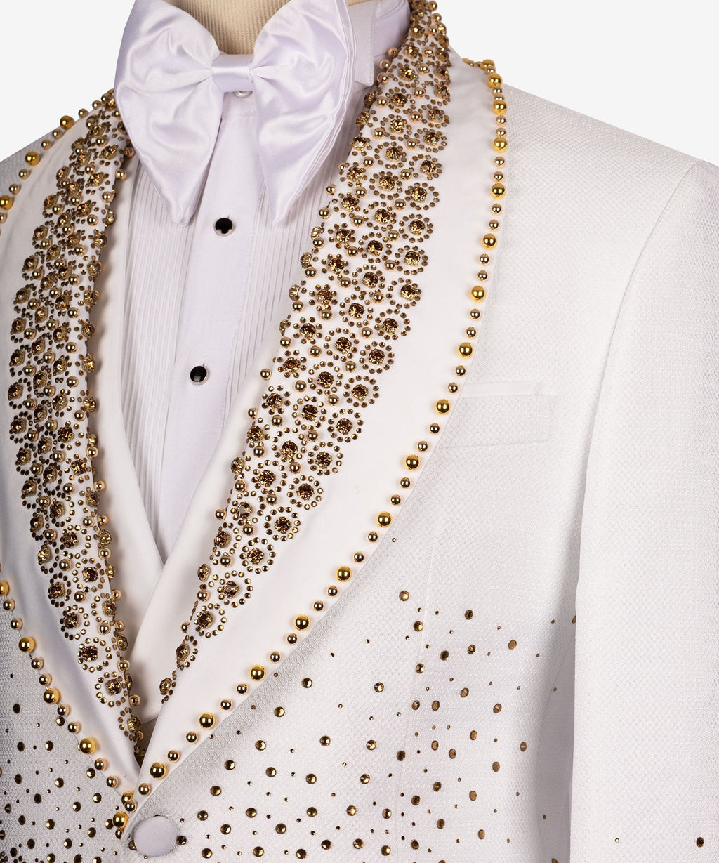 Close-up: white dress shirt and bow tie under white tuxedo with gold gem-stone lapel