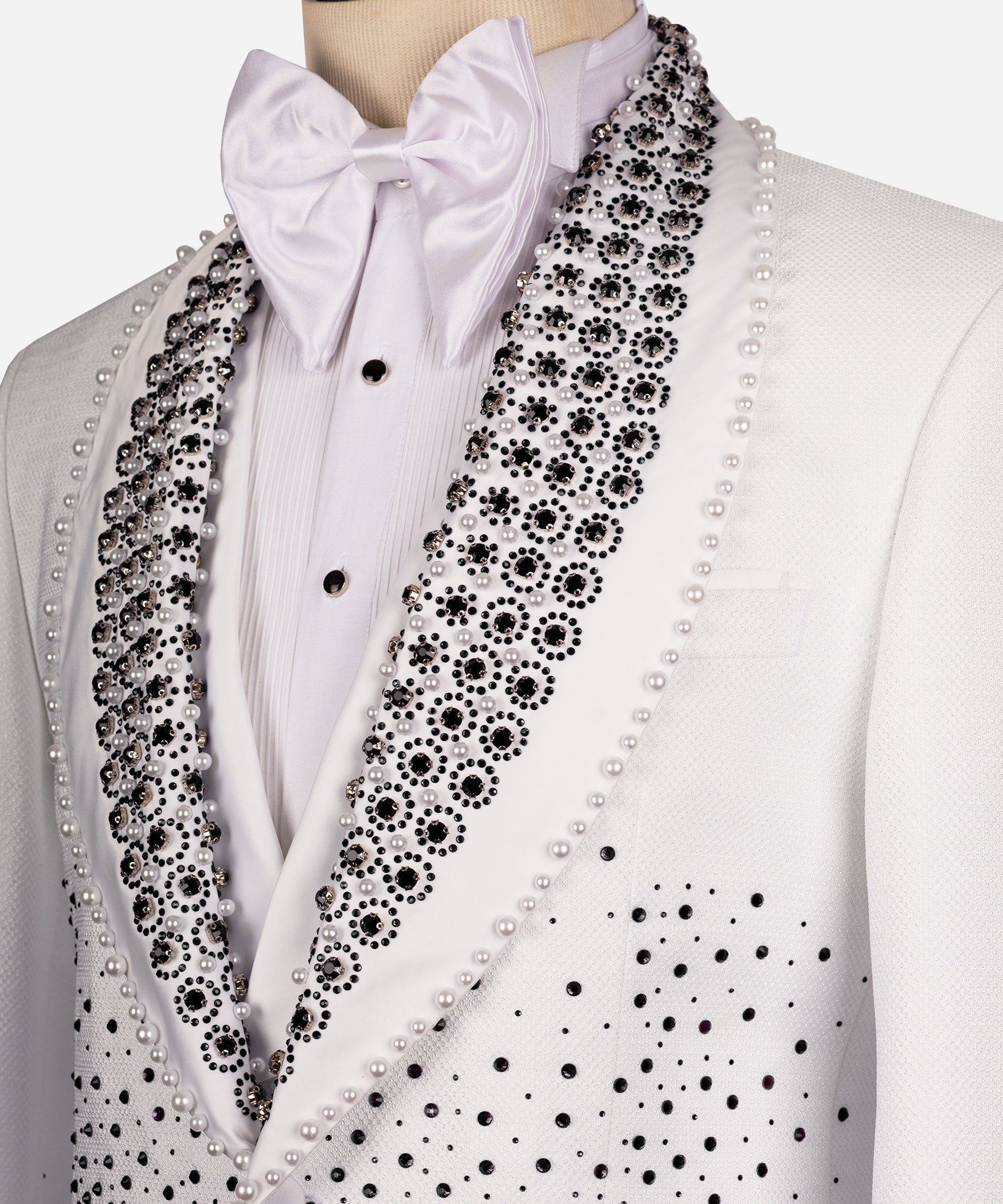 Close-up white tuxedo lapel with black gems and pearl trim, satin bow tie