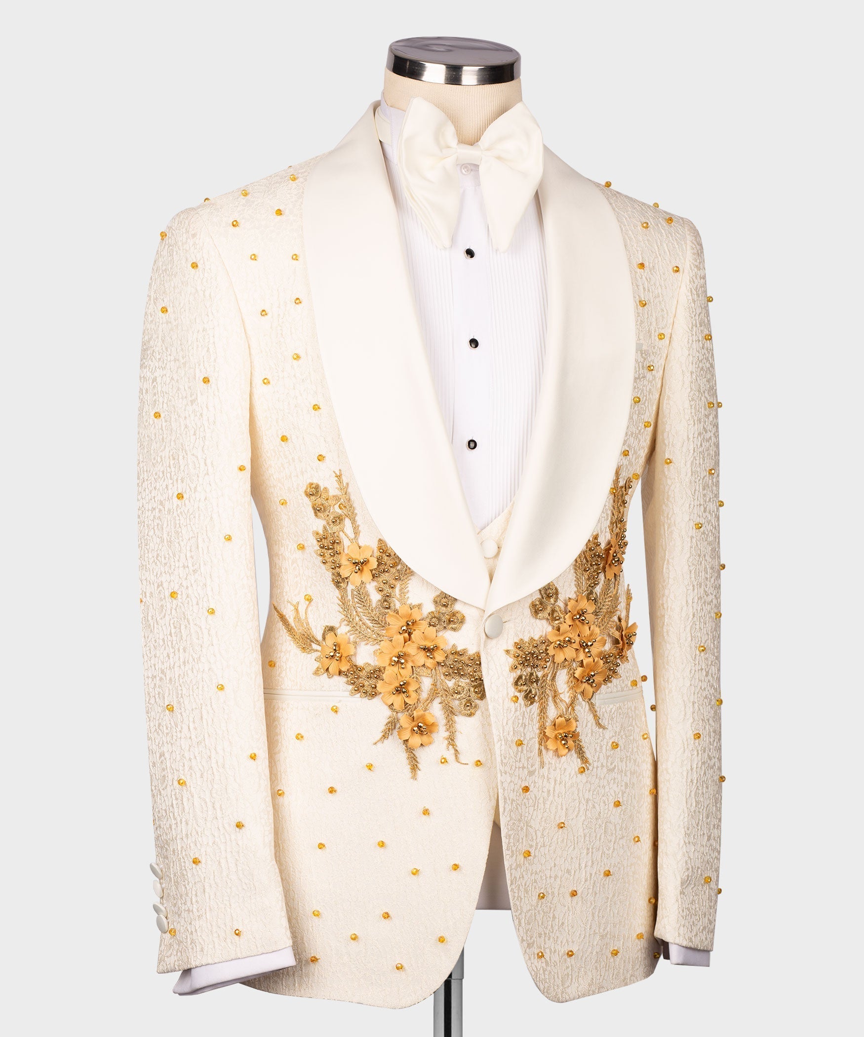 Cream gold-accent tuxedo jacket with floral embroidery and white bow-tie waistcoat