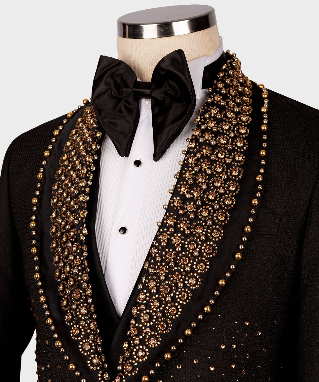 Close-up of black tuxedo jacket lapels with gold gem-like trim and black bow tie