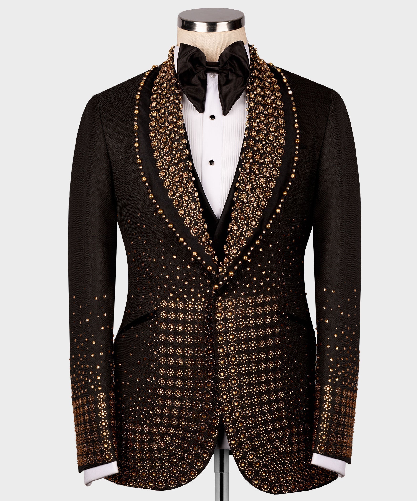 Black tuxedo jacket with dense gold gem-like trim on lapels and front panels, bow tie