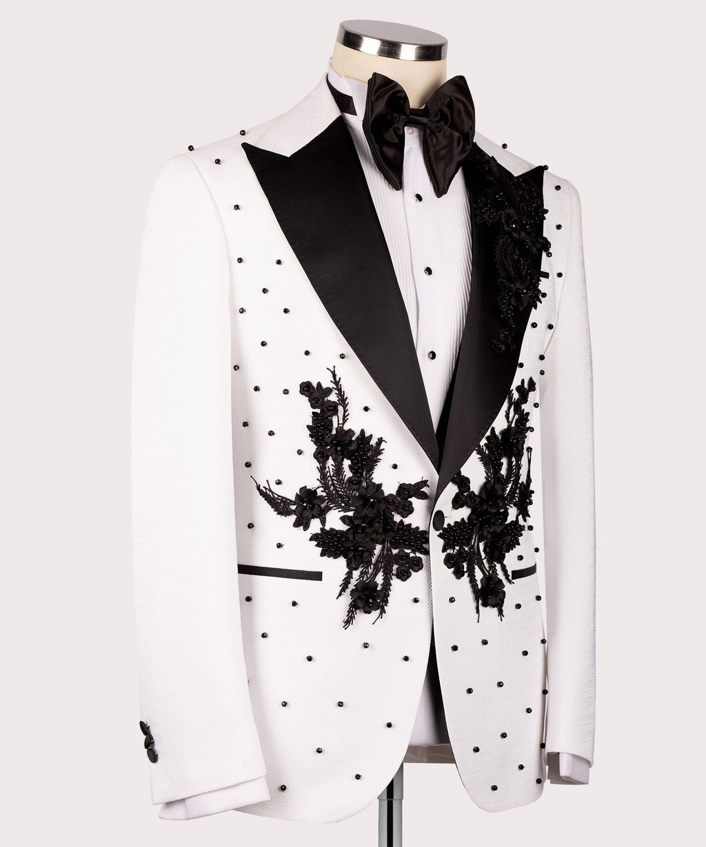 White tuxedo jacket with black satin lapels and large hand-embroidered floral sprays