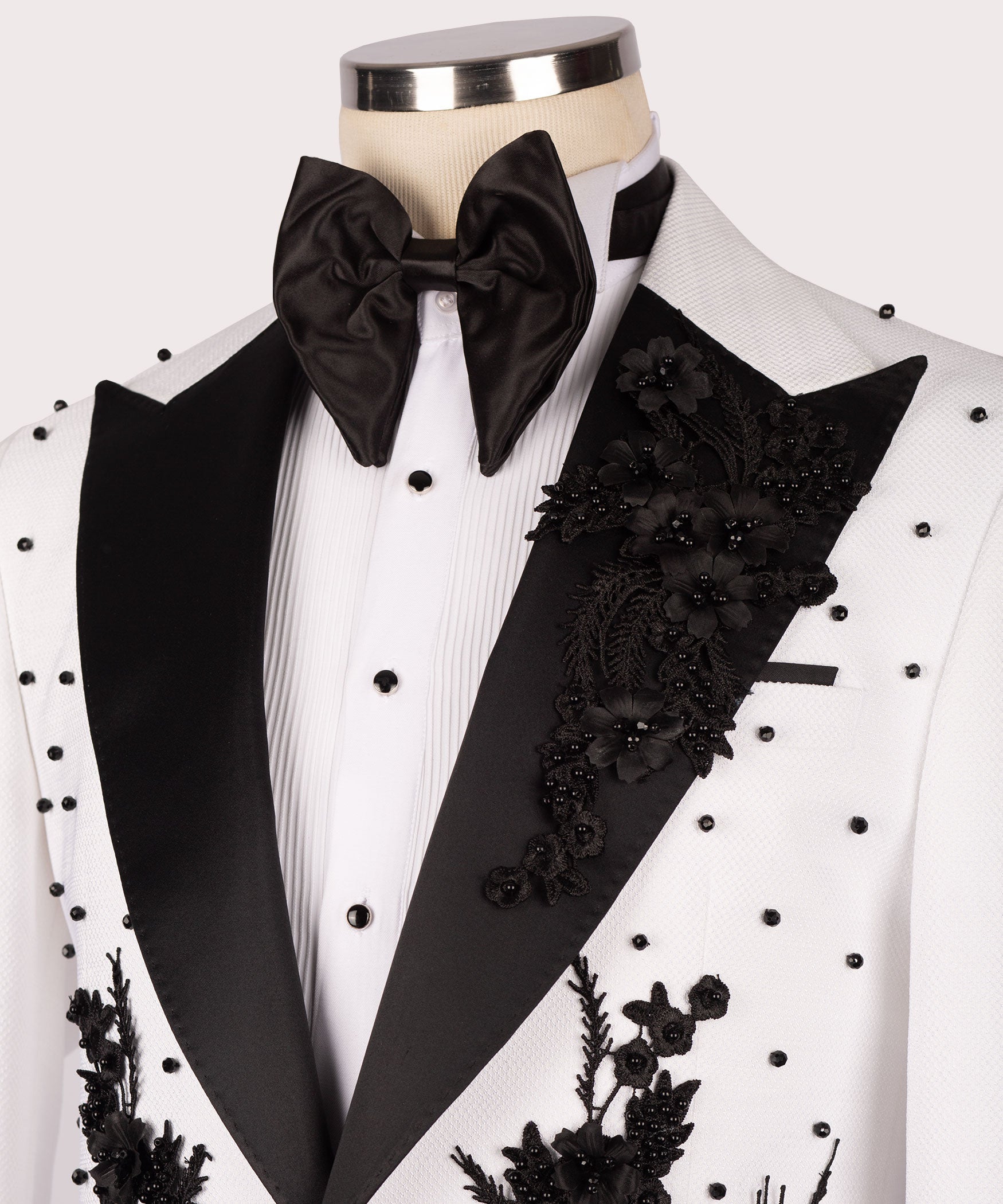 White tuxedo shirt and jacket with black bow tie and ornate black floral embroidery panel