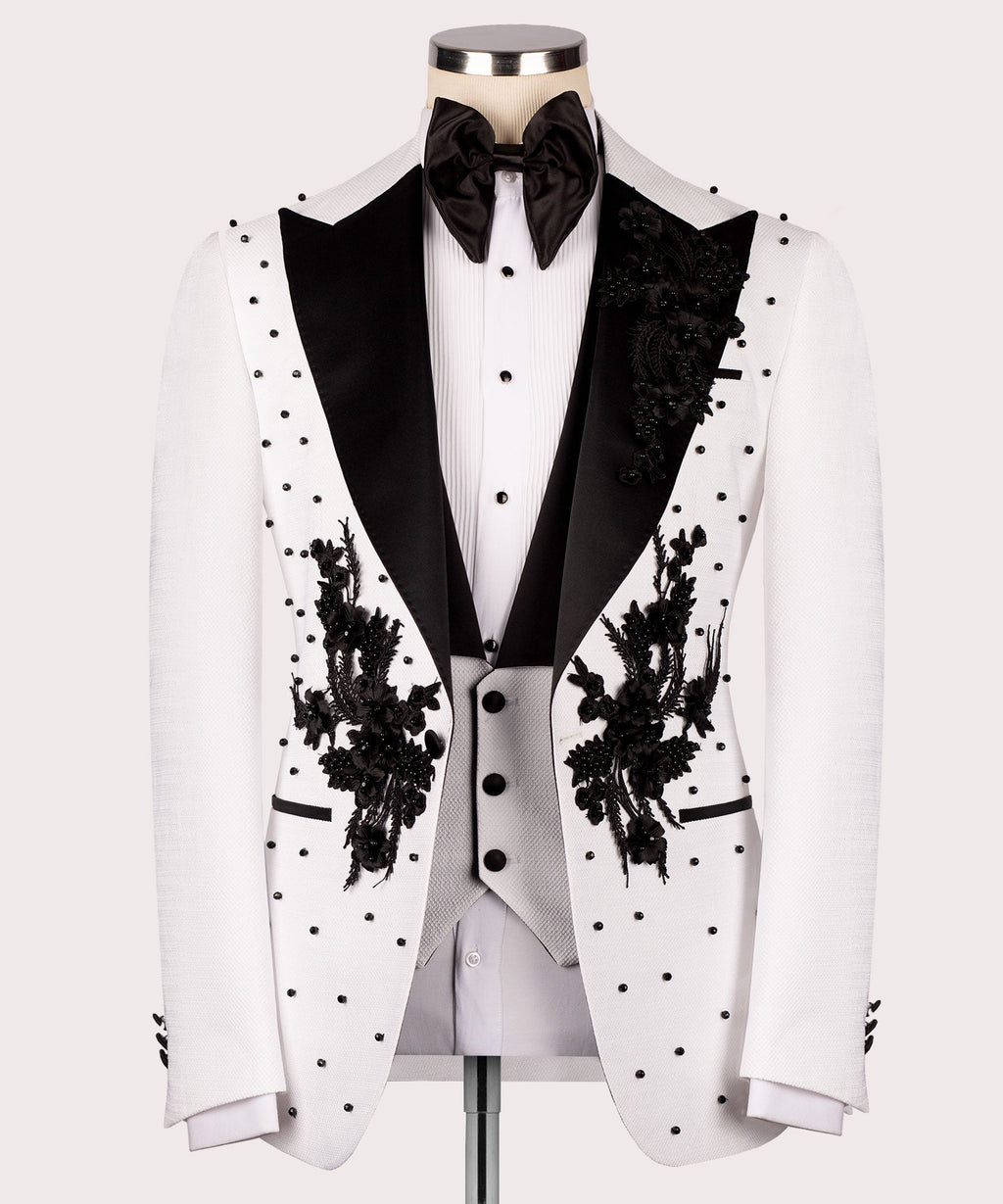White tuxedo jacket front with black satin lapels, floral embroidery, and dot pattern