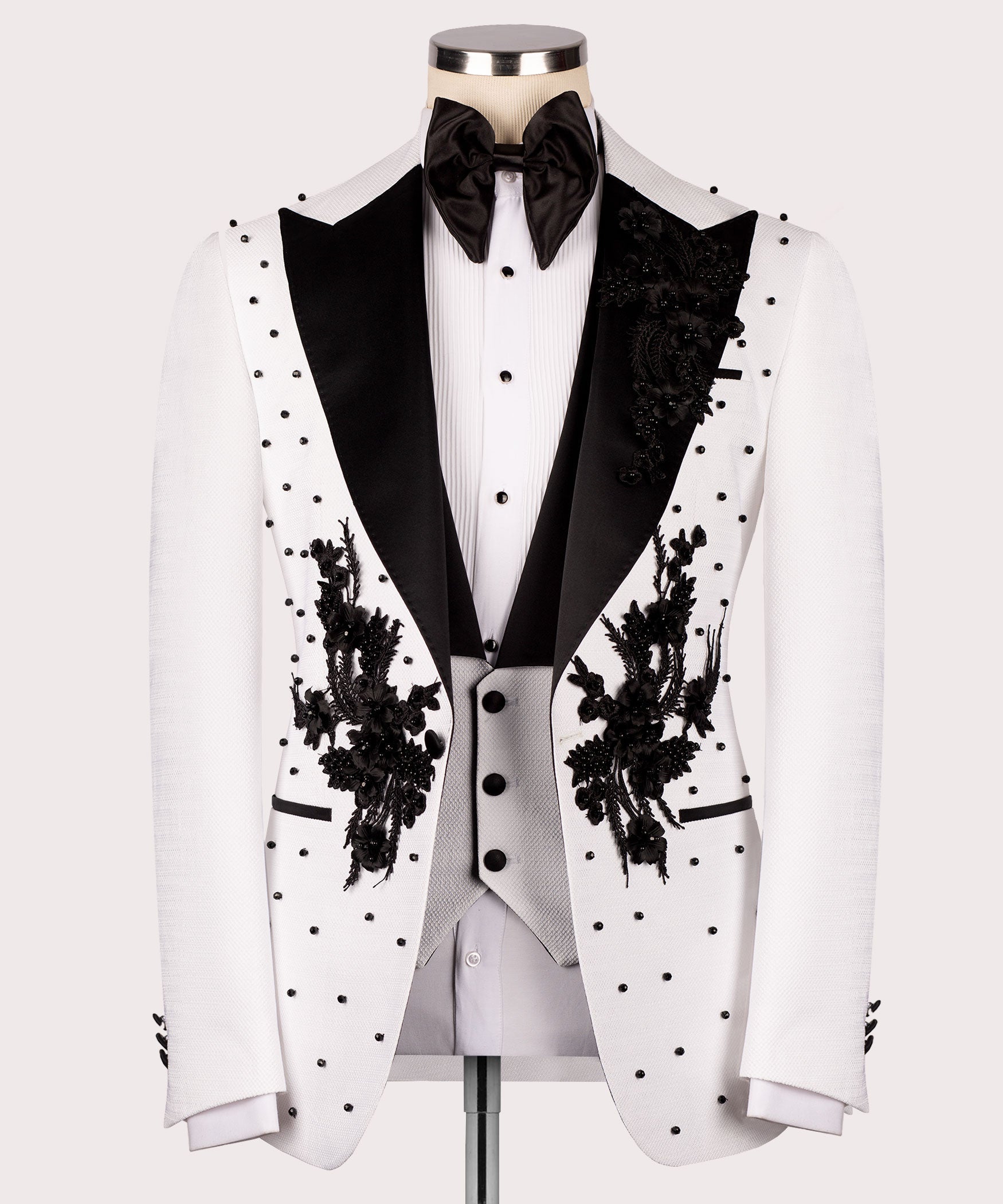 White tuxedo jacket front with black satin lapels, floral embroidery, and dot pattern