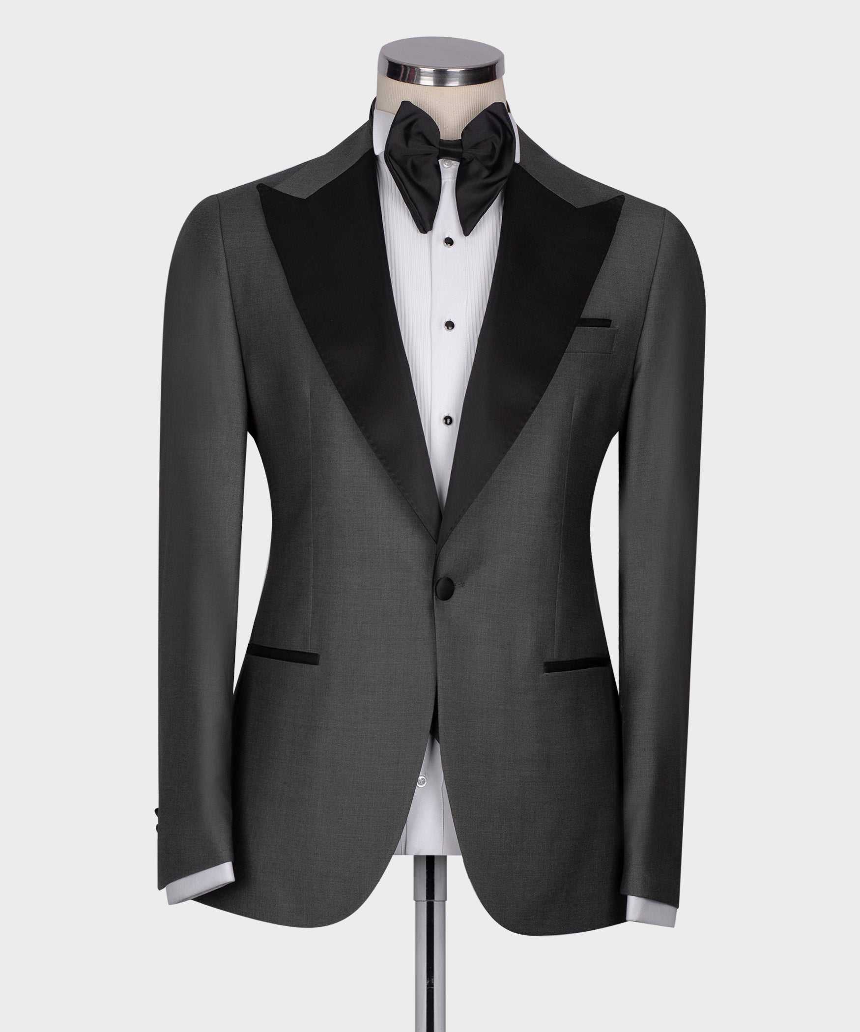 Charcoal gray tuxedo jacket front with black shawl lapels and white striped dress shirt