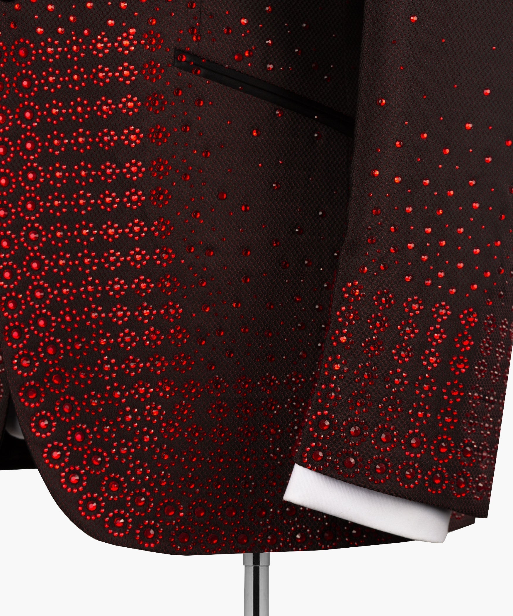 Burgundy tuxedo jacket detail with red circular embellishments and black cuff