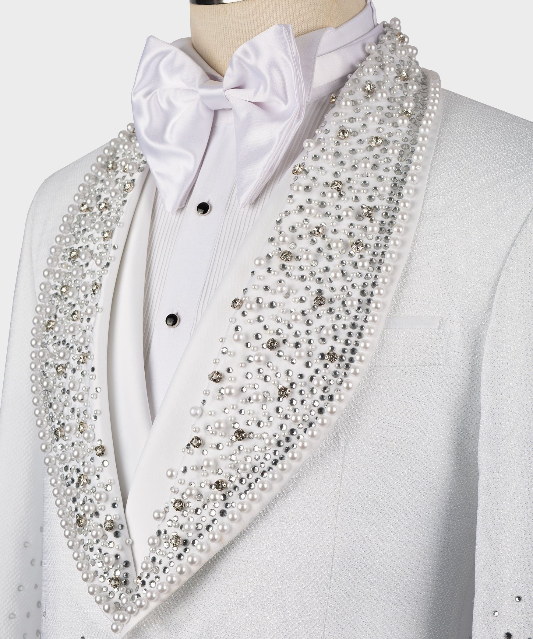 Close-up: white satin bow tie and jeweled V-shaped lapel on tuxedo jacket