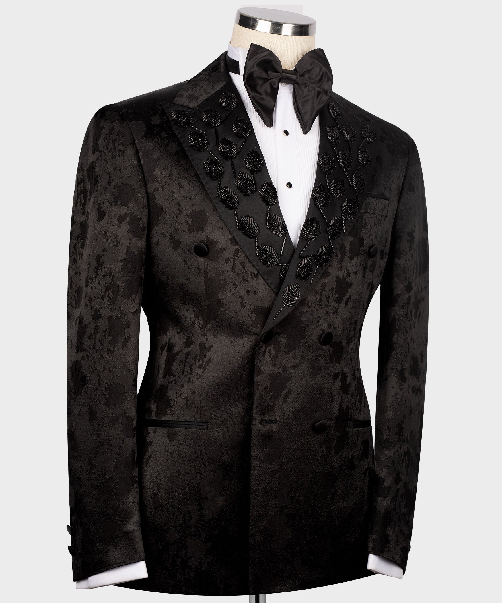 Black tuxedo jacket front view, double-breasted buttons and patterned lapel detail
