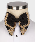 Koss Atelier black silk bow tie featuring intricate gold and crystal floral embellishments on a white dress shirt.