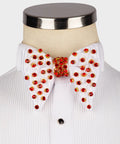 Koss Atelier white silk bow tie featuring gold-set red crystal embellishments on a white pleated dress shirt.