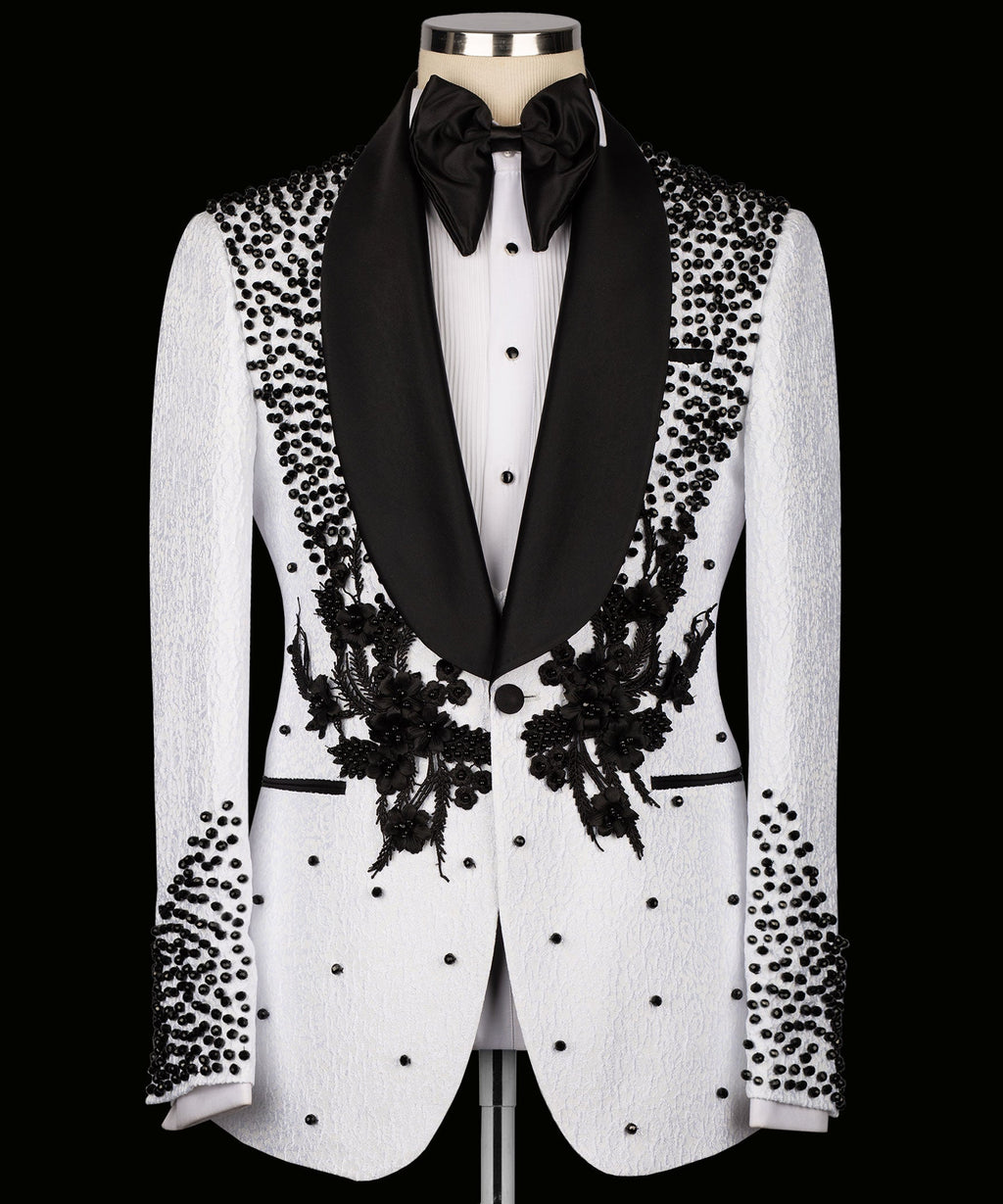 White tuxedo jacket with black shawl lapels, floral embroidery, and dotted embellishments