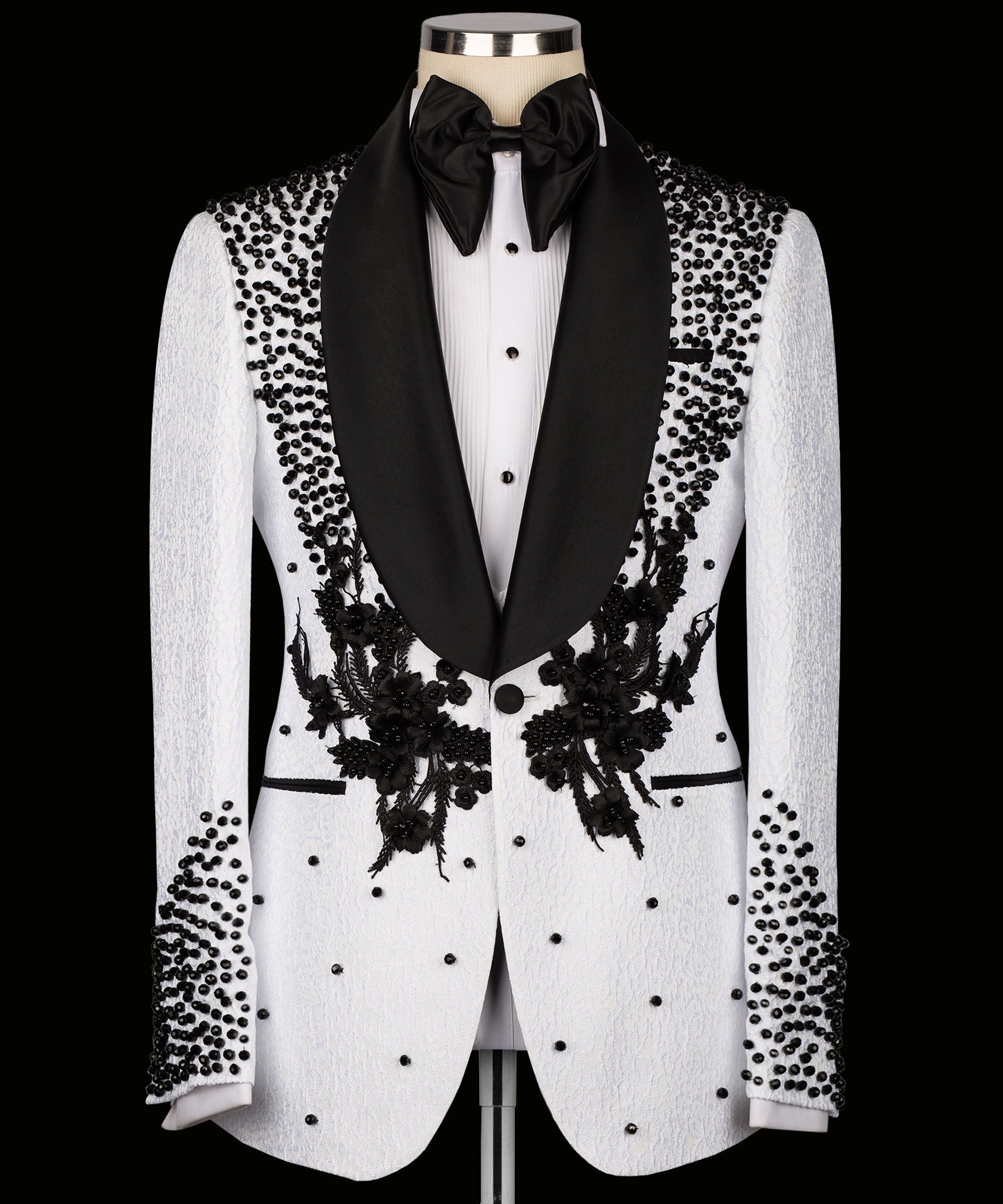 White tuxedo jacket with black shawl lapels, floral embroidery, and dotted embellishments