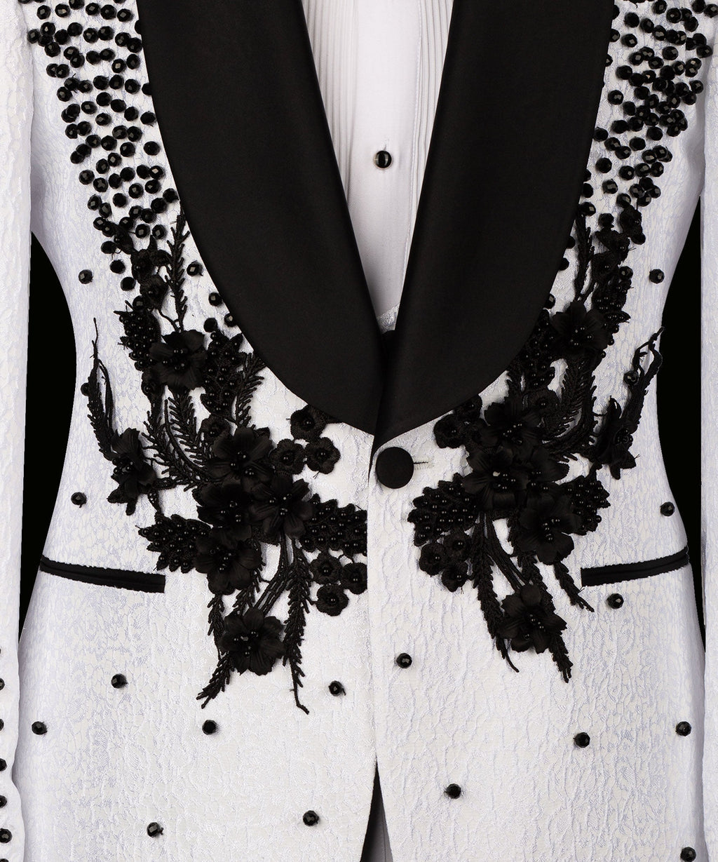Black floral embroidery along jacket edges with white button front and dotted beads
