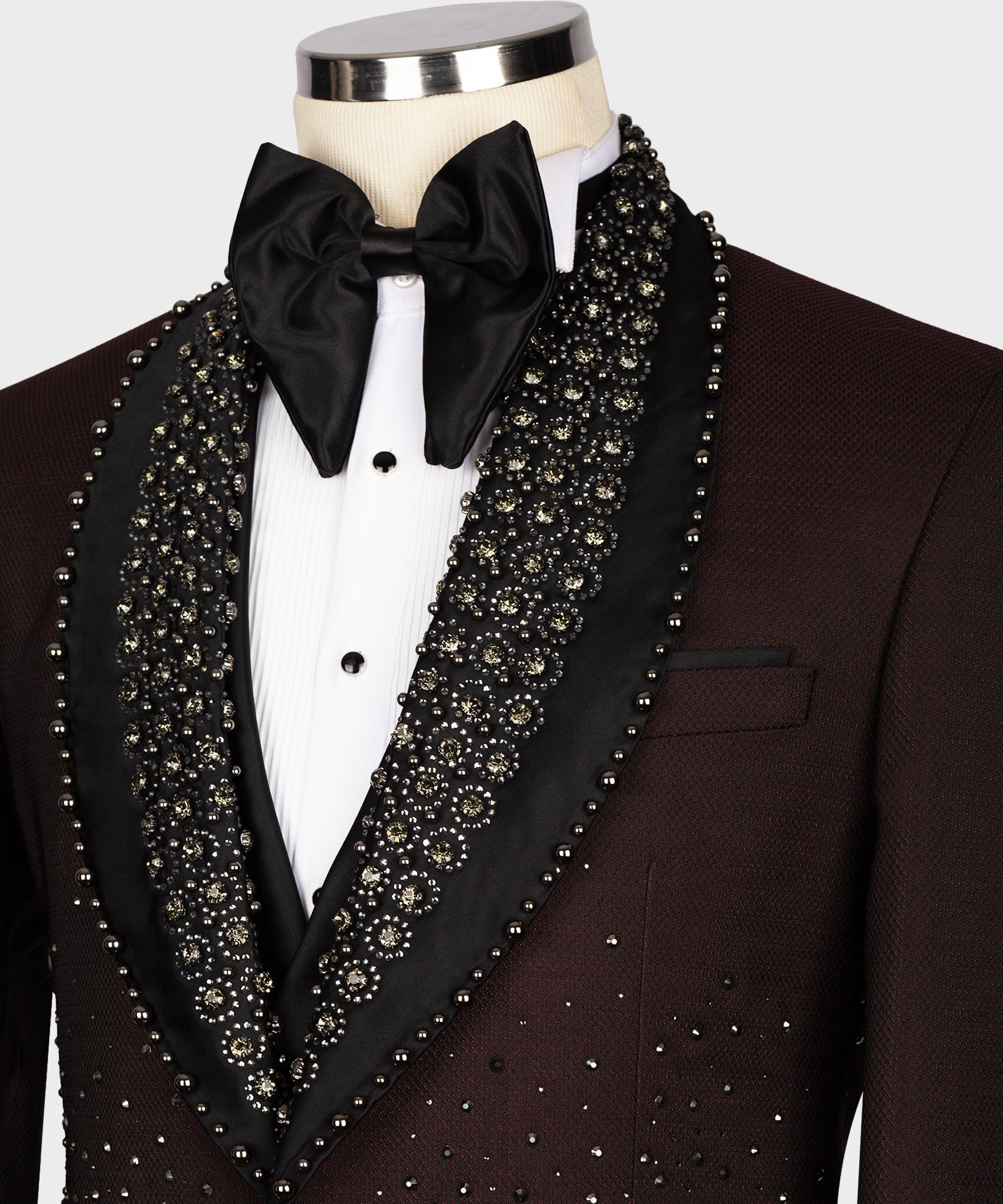 Black satin bow tie with white shirt and burgundy tuxedo lapels covered in gold-toned beads
